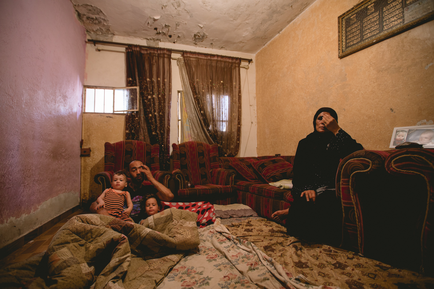  Another perspective of Amal’s home. Here she sits in the single room with her son and grandchildren.&nbsp; 