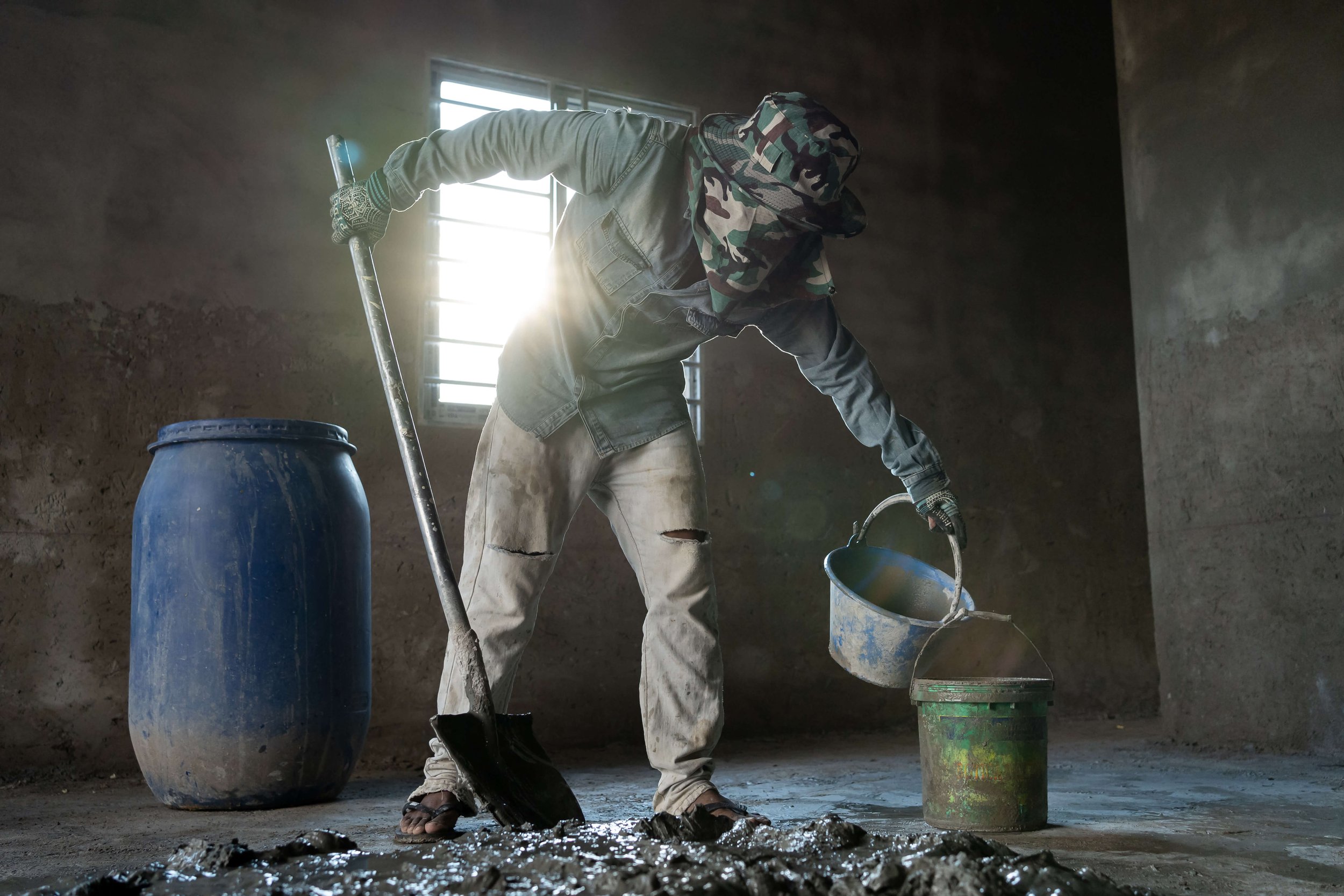  Construction worker Dieb Phearum mixes cement at a construction site on the outskirts of Phnom Penh in Kambol District. 