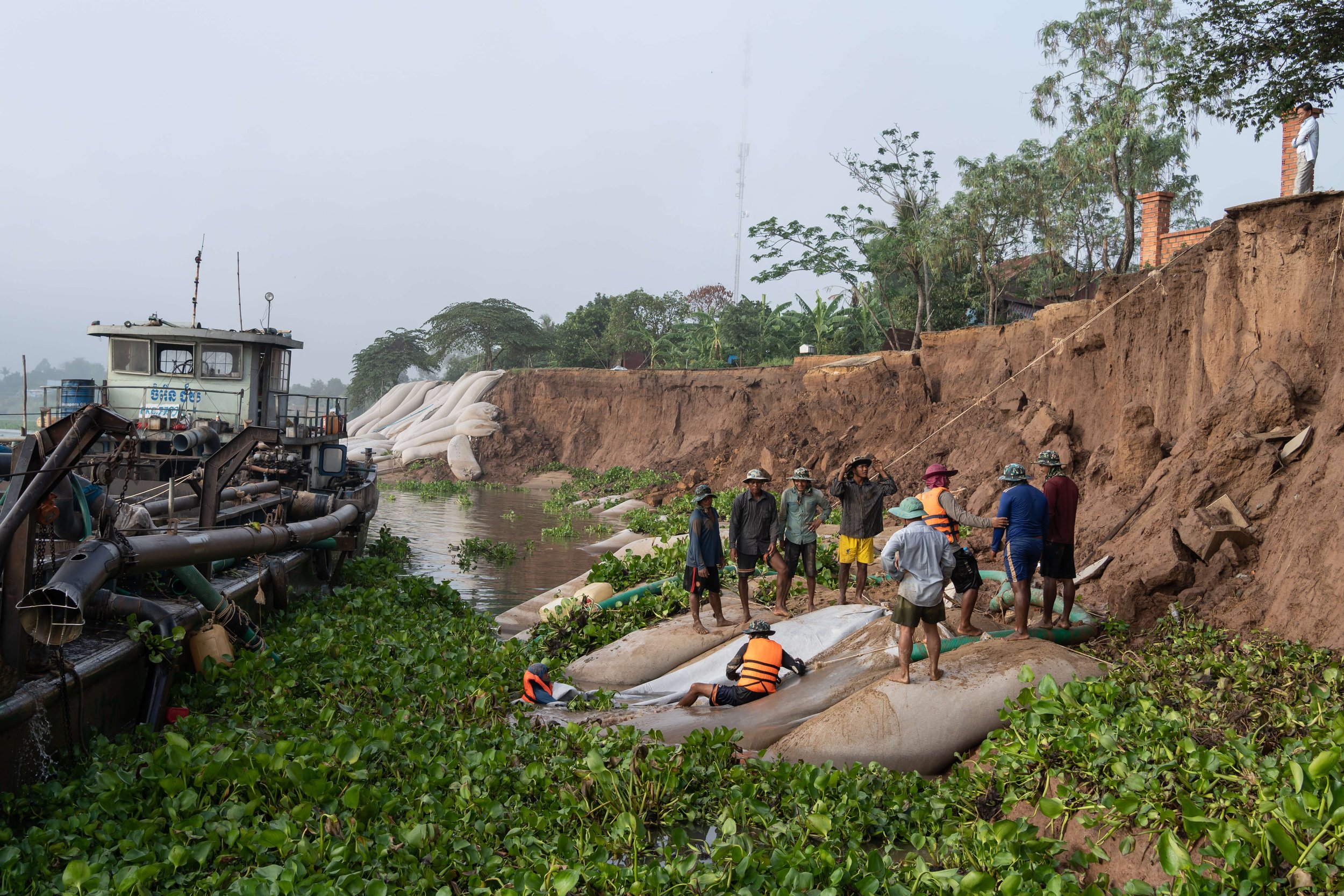  Workers fill bags with sand pumped from the Mekong to protect a very recent riverbank collapse in Boeung Leu village, Kandal Province, from further erosion. Eight families were impacted by the collapse, with four already relocated to the main road i