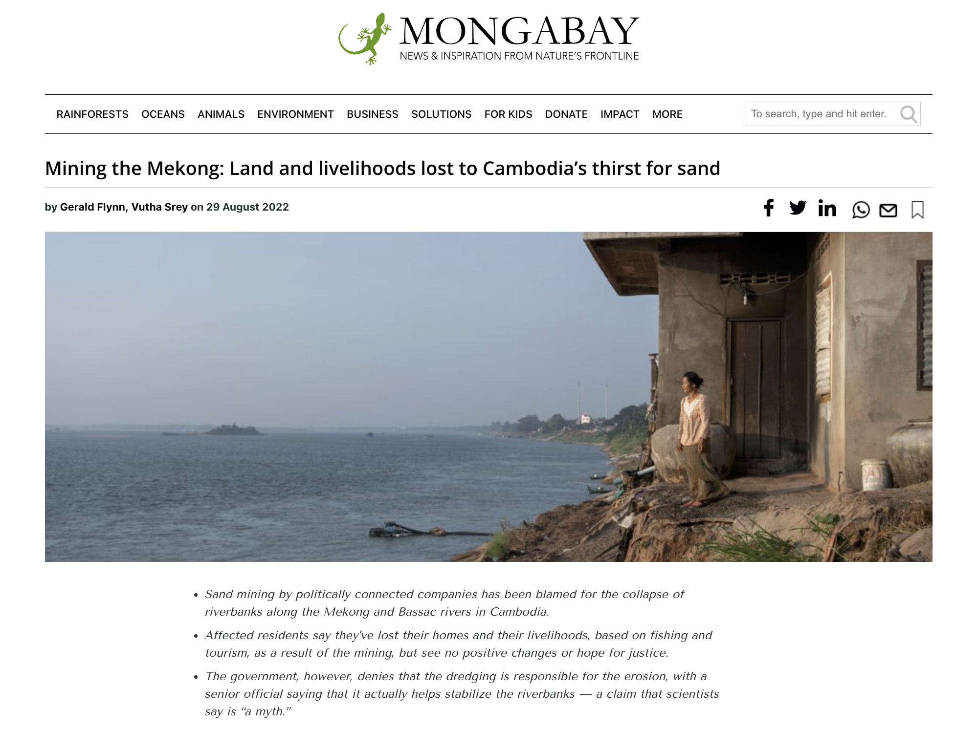 A woman stands at a riverbank collapse on the Mekong river in Cambodia.png