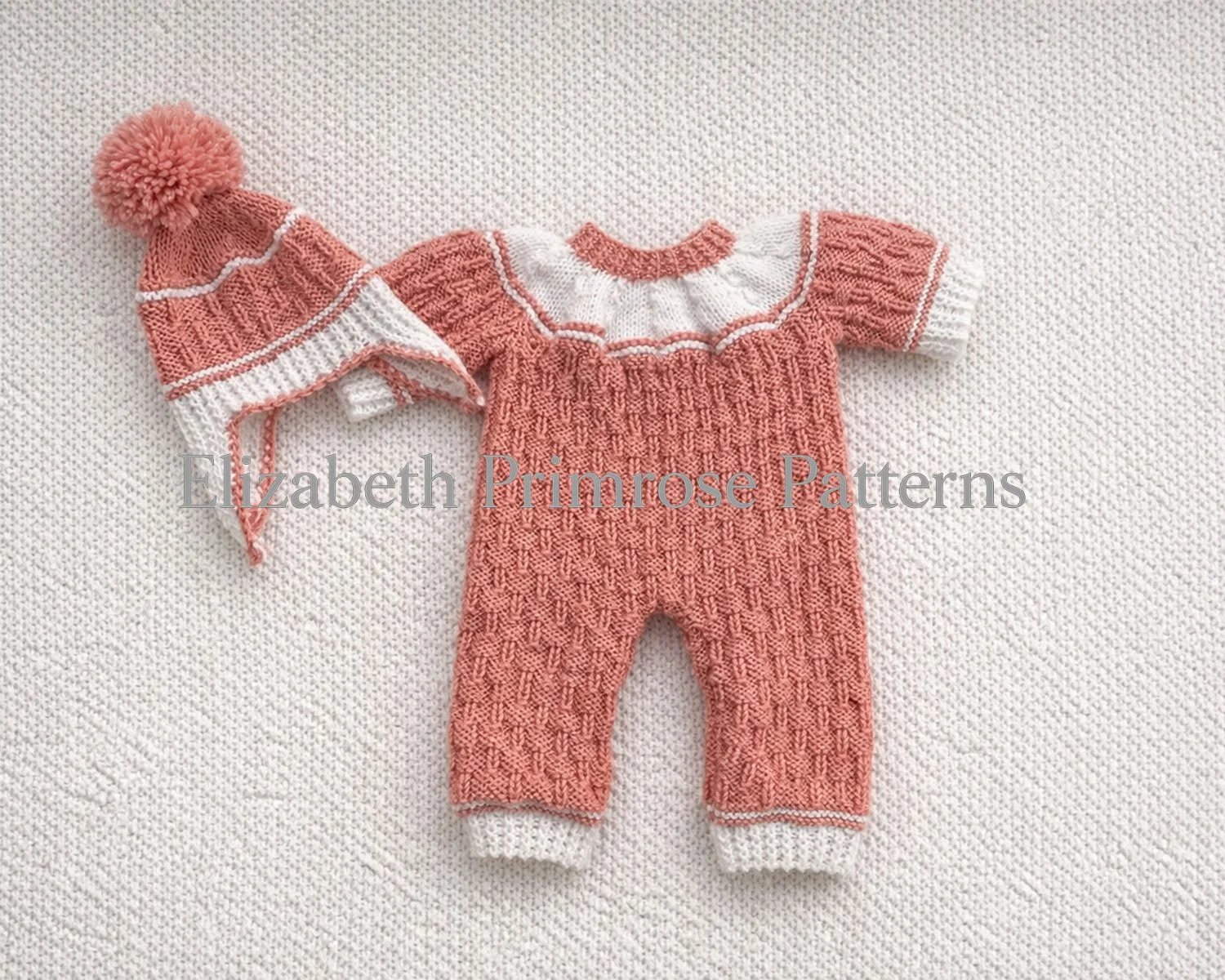 Baby romper and matching hat in coral and white yarn, displayed on a textured knitted background with clear stitch detail and soft, even lighting.