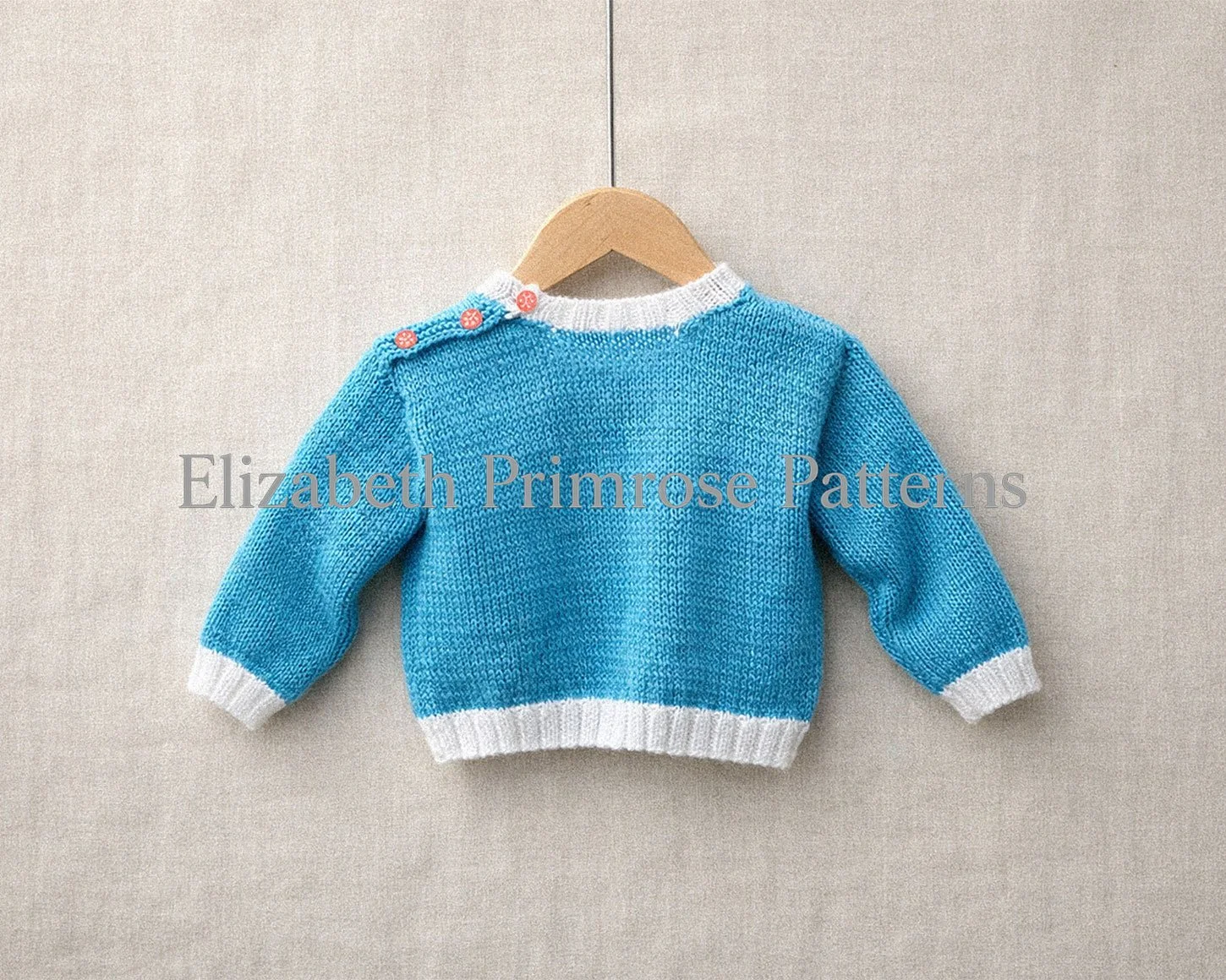 Turquoise knitted baby jumper with white ribbing and red shoulder buttons, shown from the back on a wooden hanger against a smooth beige fabric background.