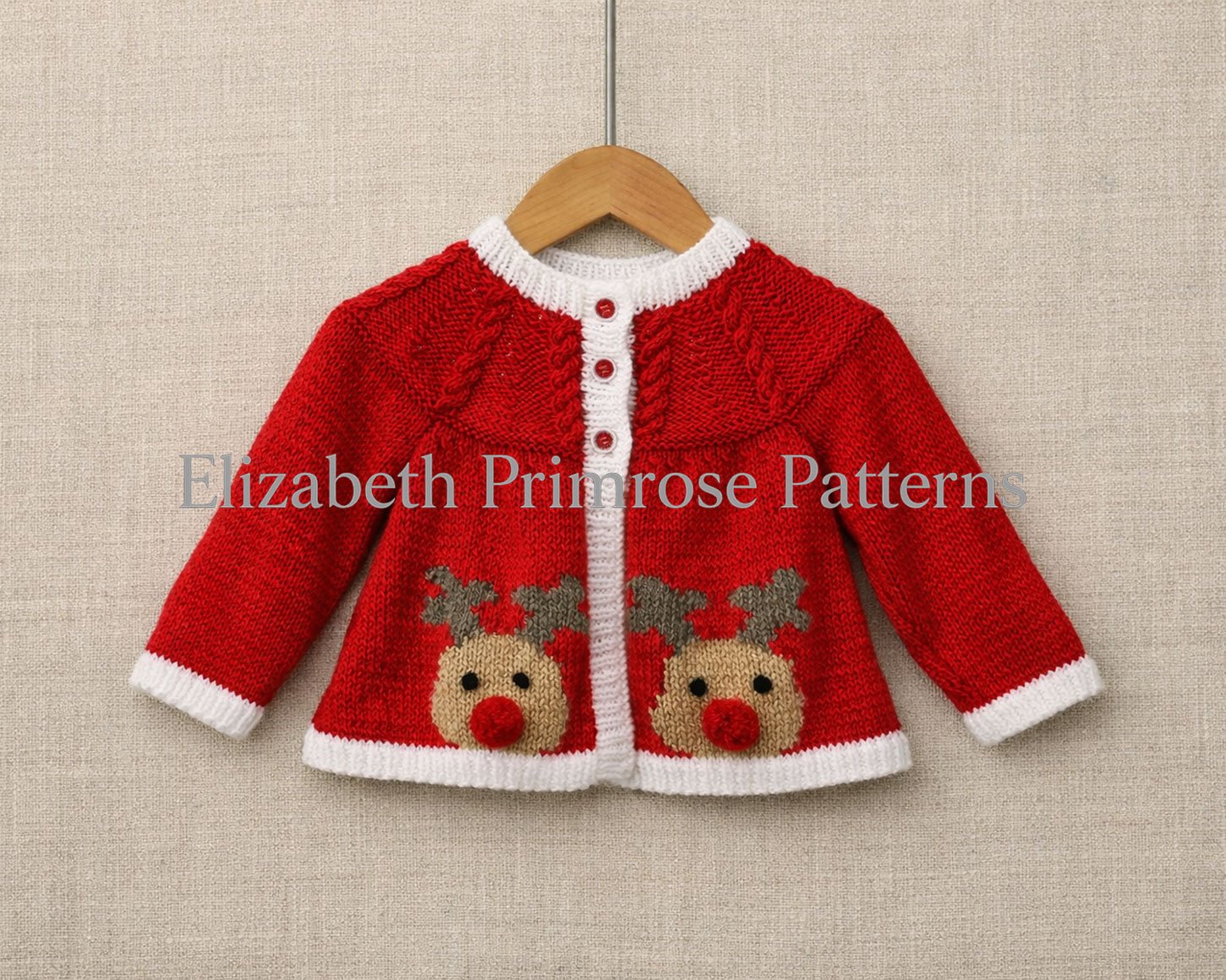 Red baby reindeer cardigan on a wooden hanger against a beige fabric backdrop, showing crisp stitches, white trims, and two festive Rudolph motifs.