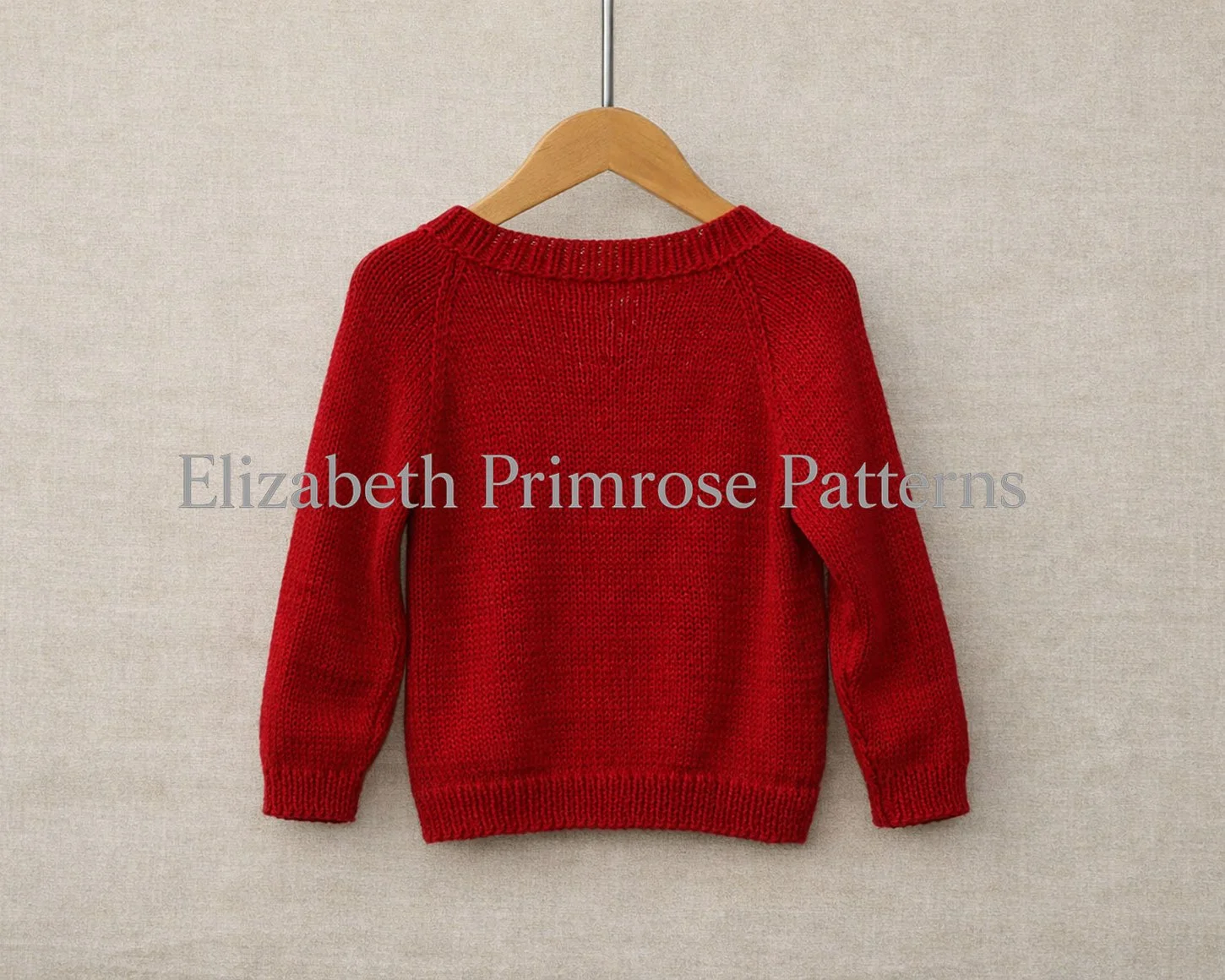 Red knitted jumper shown from the back, featuring simple raglan shaping and ribbed edges, hanging neatly on a wooden hanger.