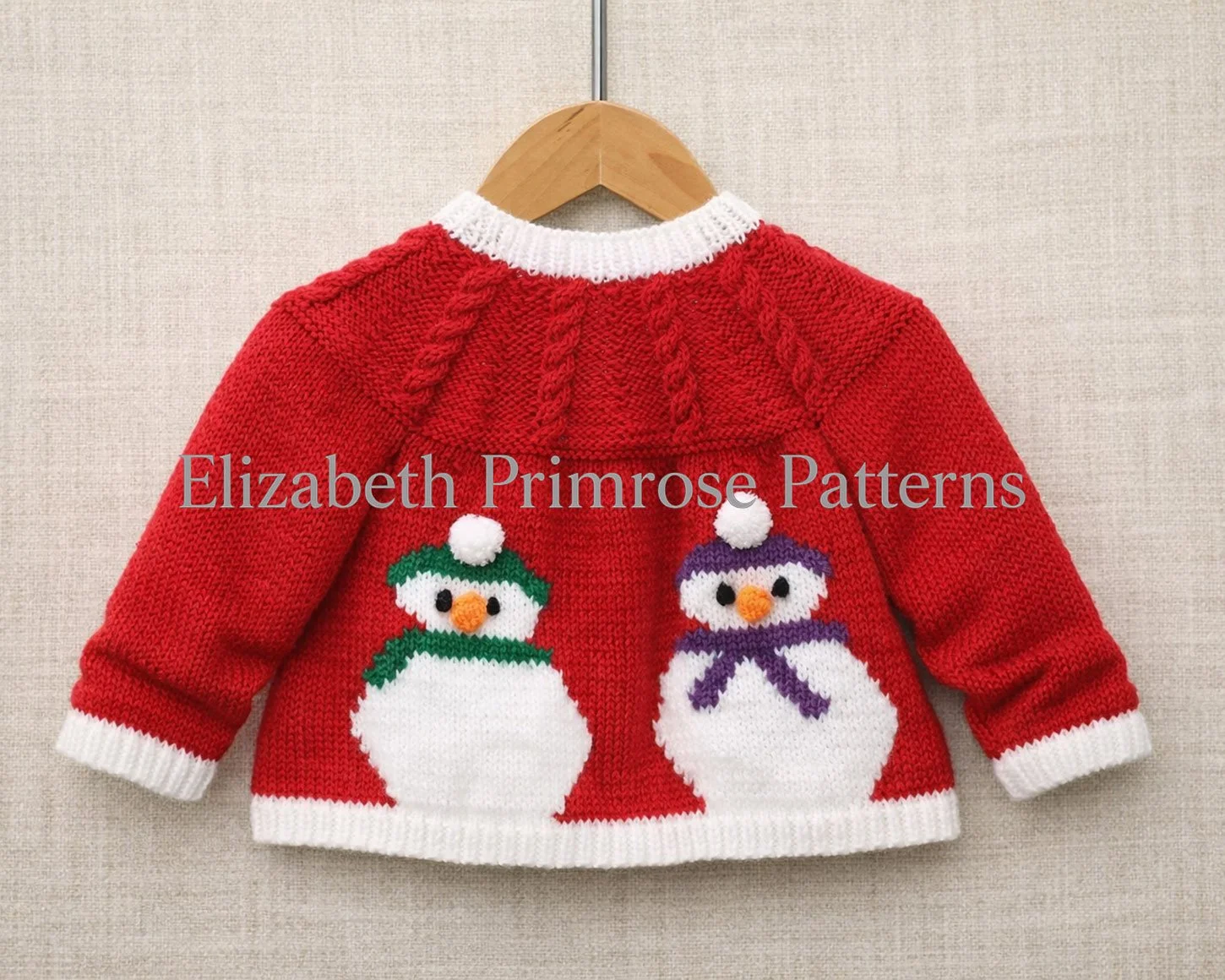 Back of red children’s Christmas jacket with two colourful snowmen motifs and a cabled yoke, displayed on a wooden hanger against beige linen.
