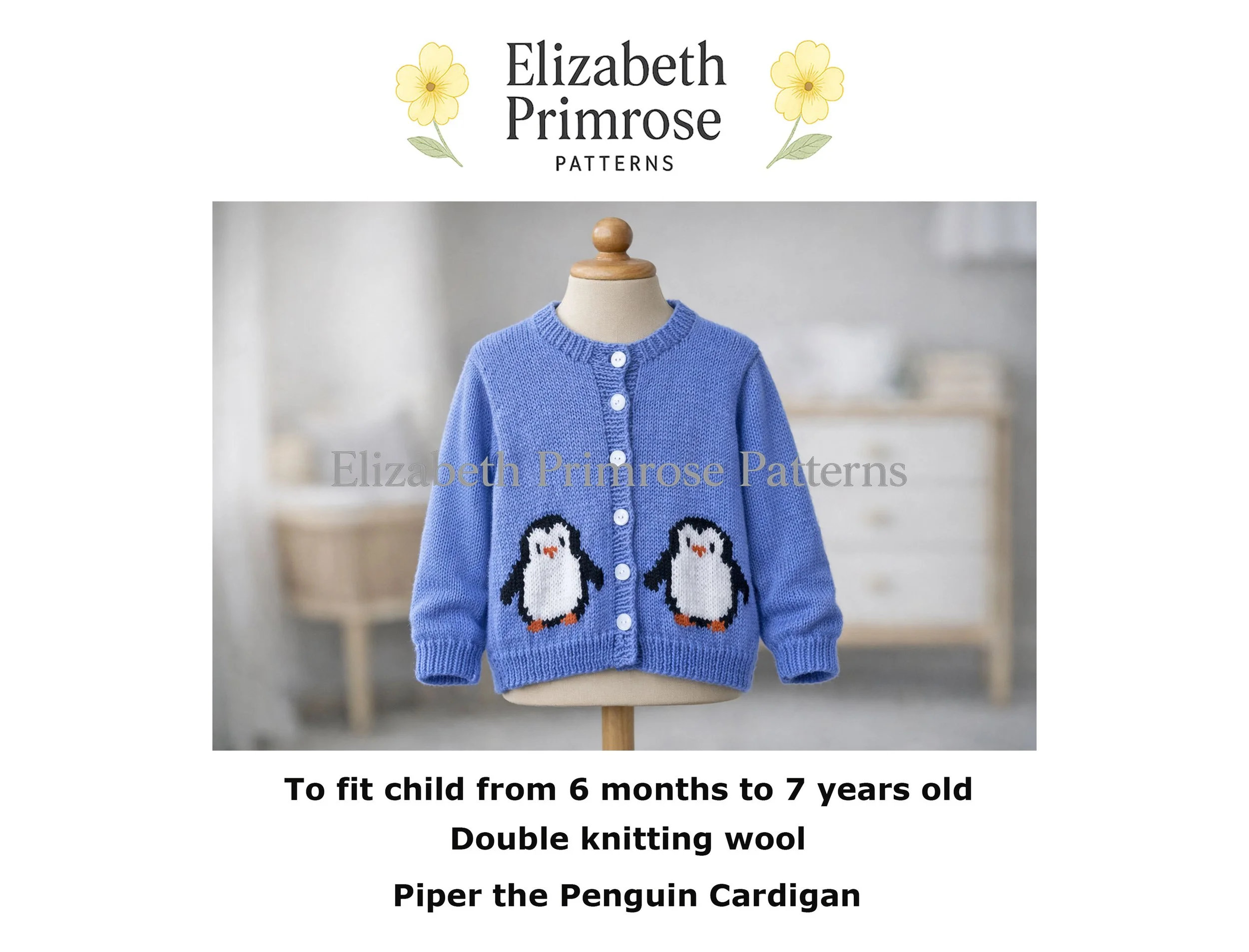 Hand-knitted blue children’s cardigan with penguin motifs, displayed on a wooden-topped mannequin in a softly lit Scandinavian nursery.