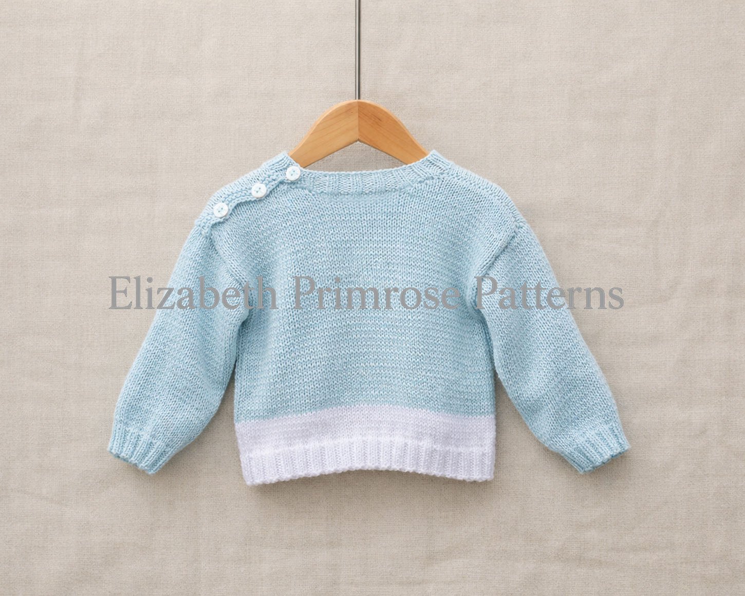 Back view of of jumper in light blue wool hanging neatly on a wooden hanger with a simple neutral backdrop.