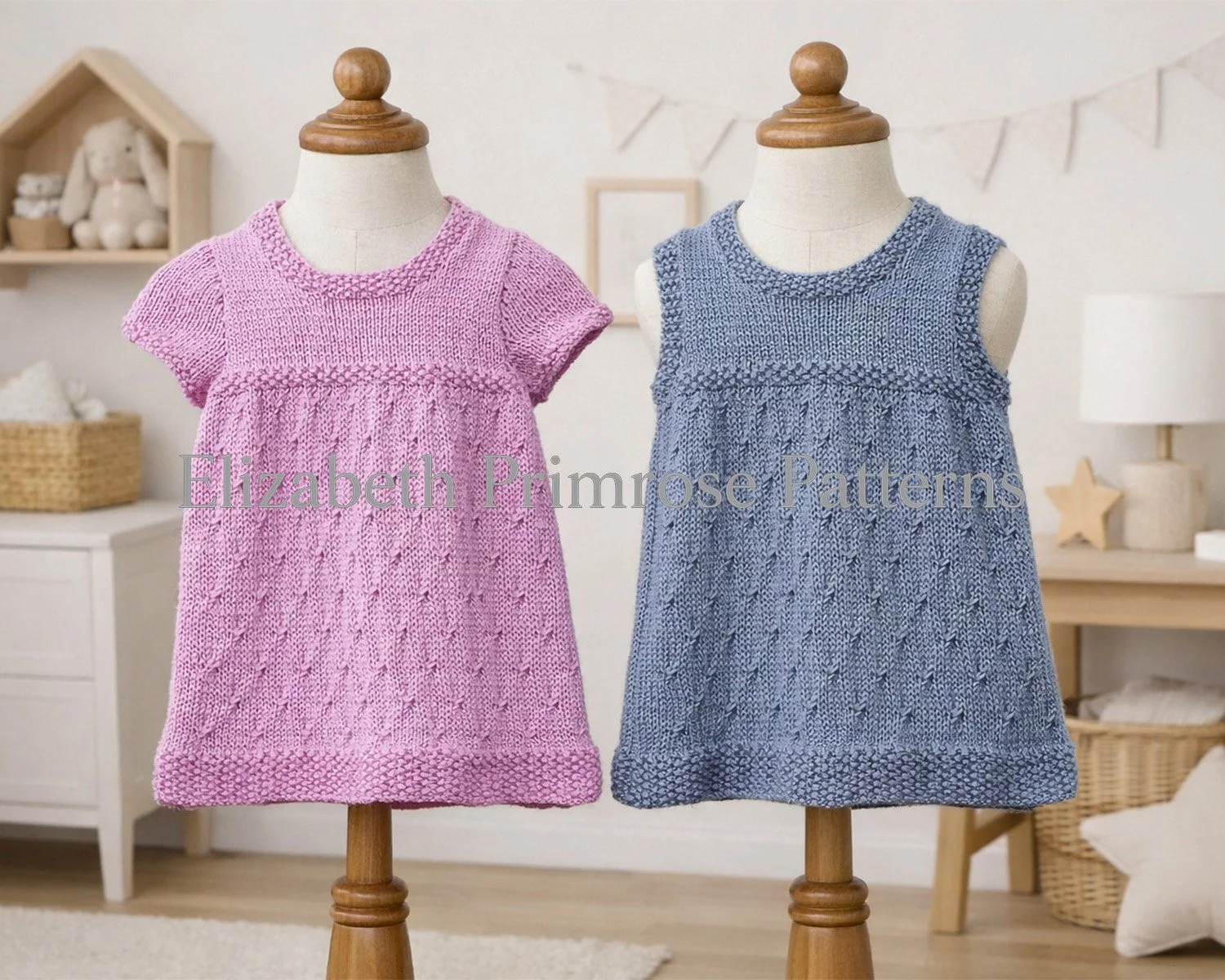 Pink and grey knitted baby dresses displayed on wooden dress forms in a softly lit nursery setting, with gentle décor creating a warm, homely atmosphere.