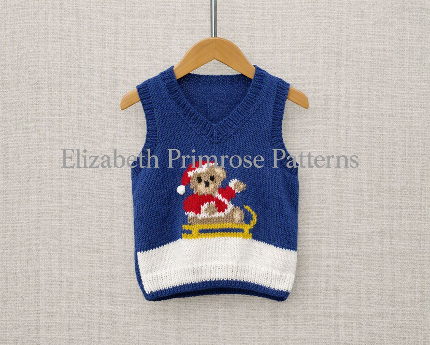 Festive hand-knitted round neck tank top featuring Santa teddy bear motif on yellow sled, displayed on light fabric backdrop.