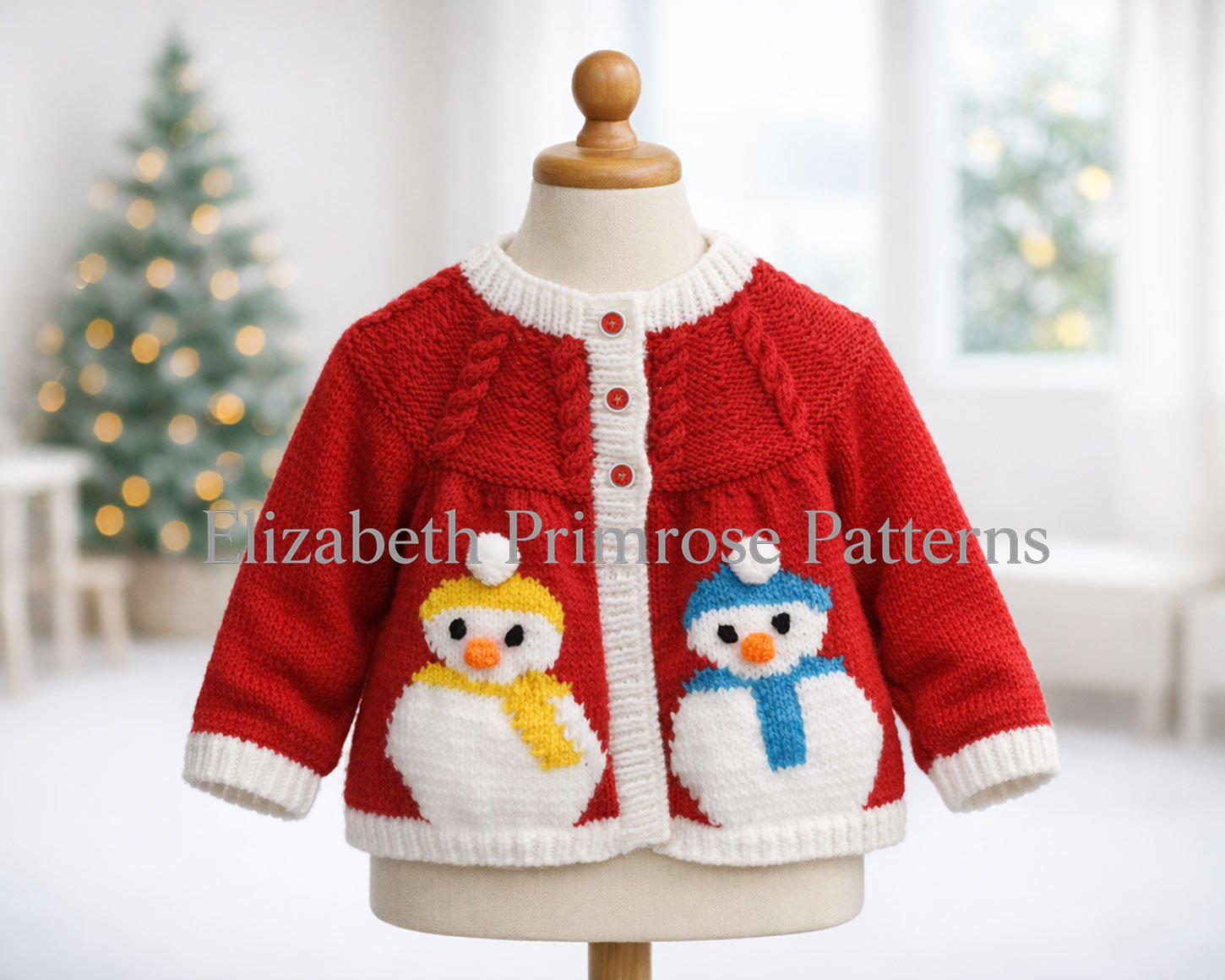 Knitted red cardigan with white trims and snowman motifs displayed on a child’s mannequin against a blurred Christmas tree and bright winter background.