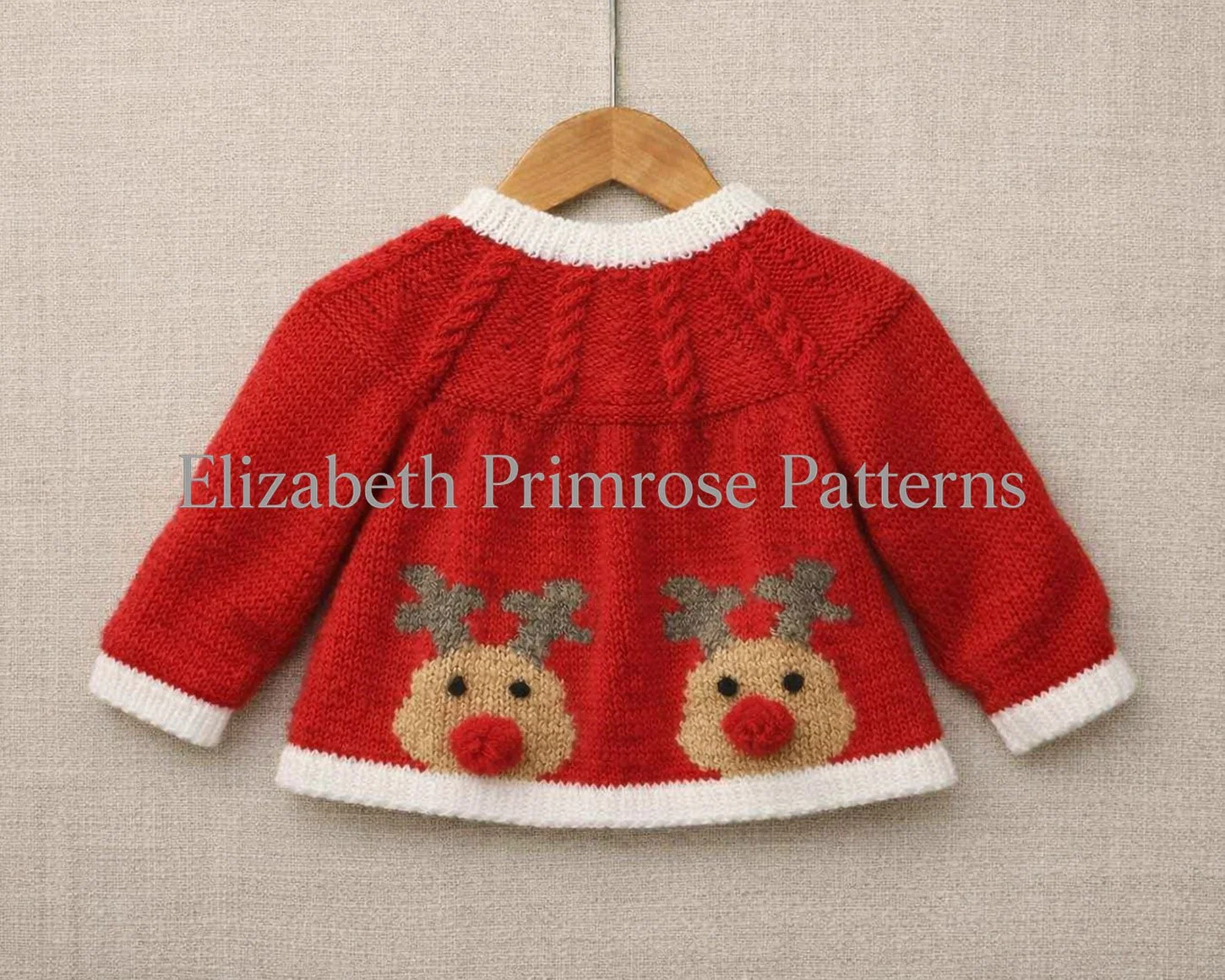 Red baby cardigan back view on a wooden hanger, with white trims and two small reindeer motifs against a soft beige fabric background.