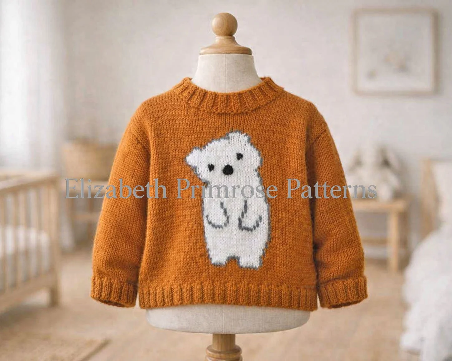 Orange knitted jumper featuring a white bear design, shown on a child’s mannequin in a warm, blurred nursery room.