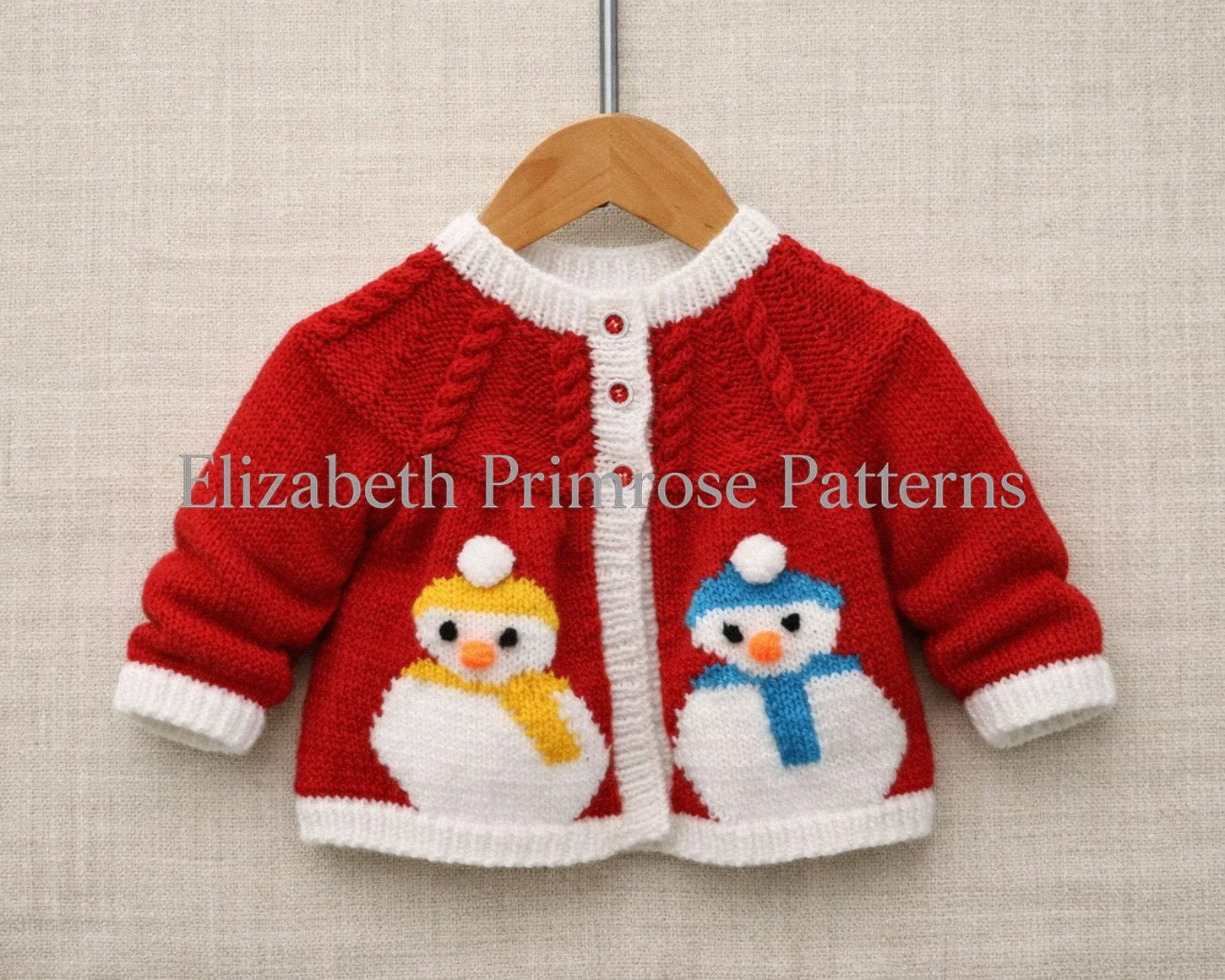 Red children’s Christmas jacket with two intarsia snowmen, white trim, and three buttons, displayed on a wooden hanger against a soft beige background.