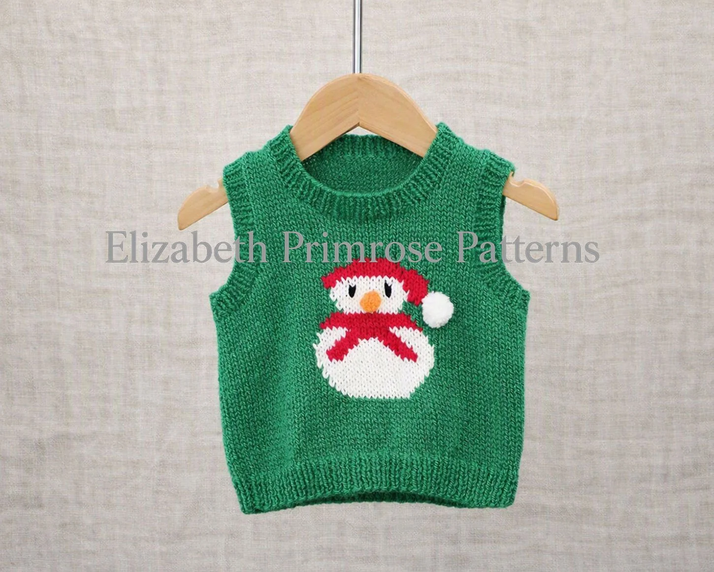 Festive snowman tank top with round neck on a wooden hanger against a linen backdrop.