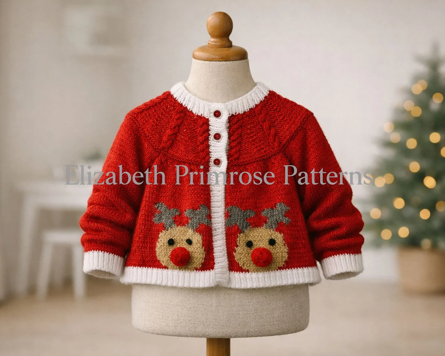 Knitted red reindeer cardigan displayed on a child’s mannequin, crisp stitches and white edging visible, with a softly lit Christmas tree and furniture blurred in the background.
