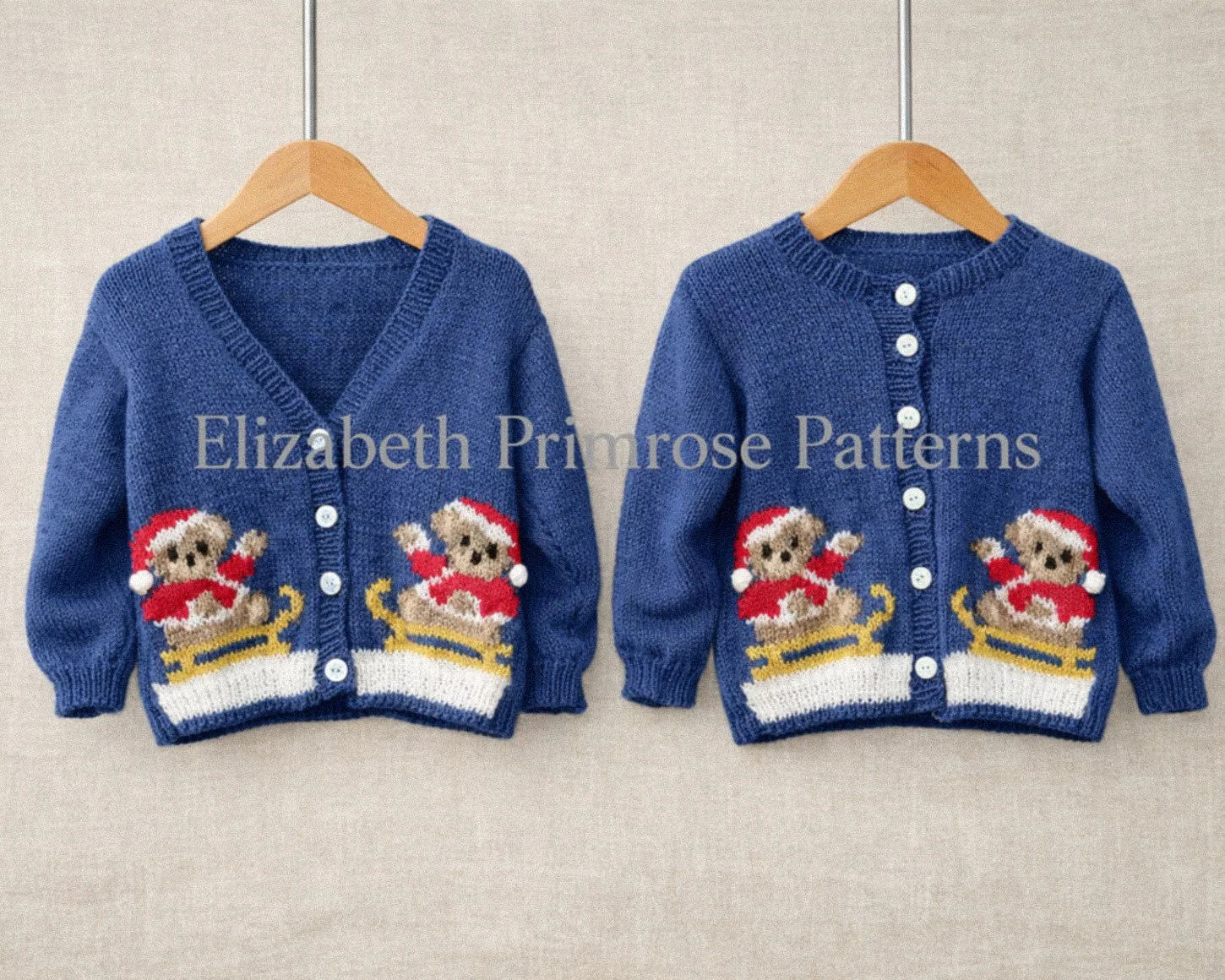 Blue children’s cardigans with festive teddy bears on sleighs, shown on wooden hangers against a soft beige background.