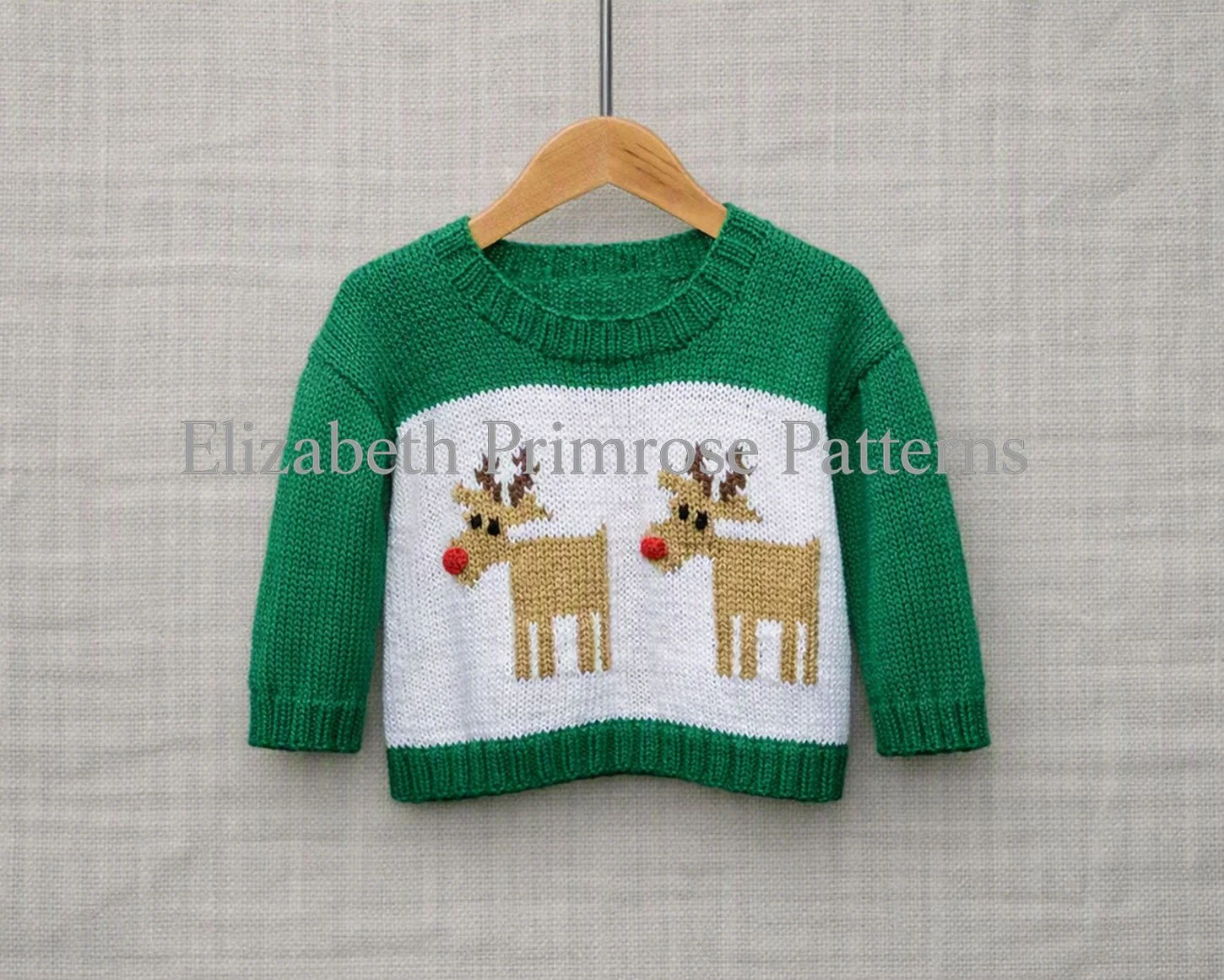 Festive hand-knitted green sweater featuring twin red nosed reindeers, displayed on hanger before neutral backdrop.