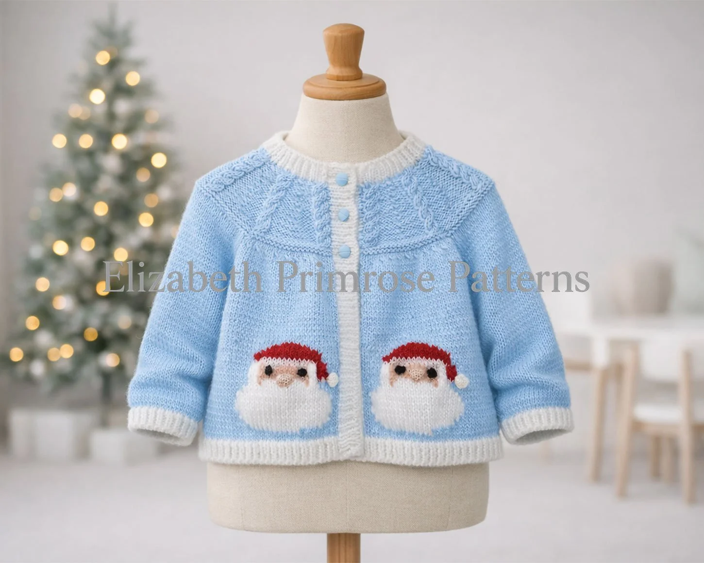Festive blue baby cardigan featuring Santa faces and white edging, displayed on a mannequin before a softly lit Christmas tree.