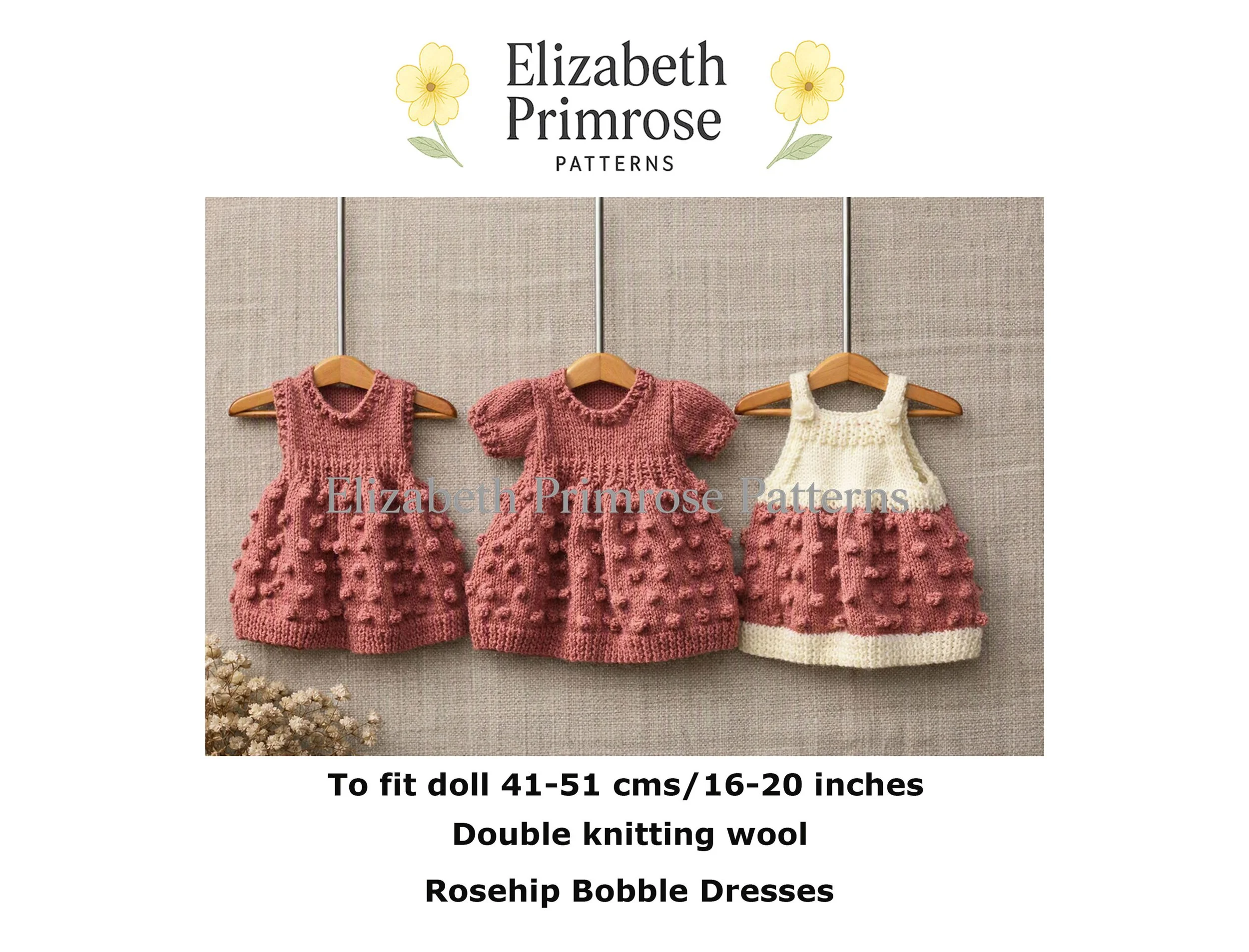 Three knitted doll dresses in pink and cream hang on tiny wooden hangers, showcasing sleeveless, short sleeve, and two-tone styles with a textured bobble stitch skirt pattern.