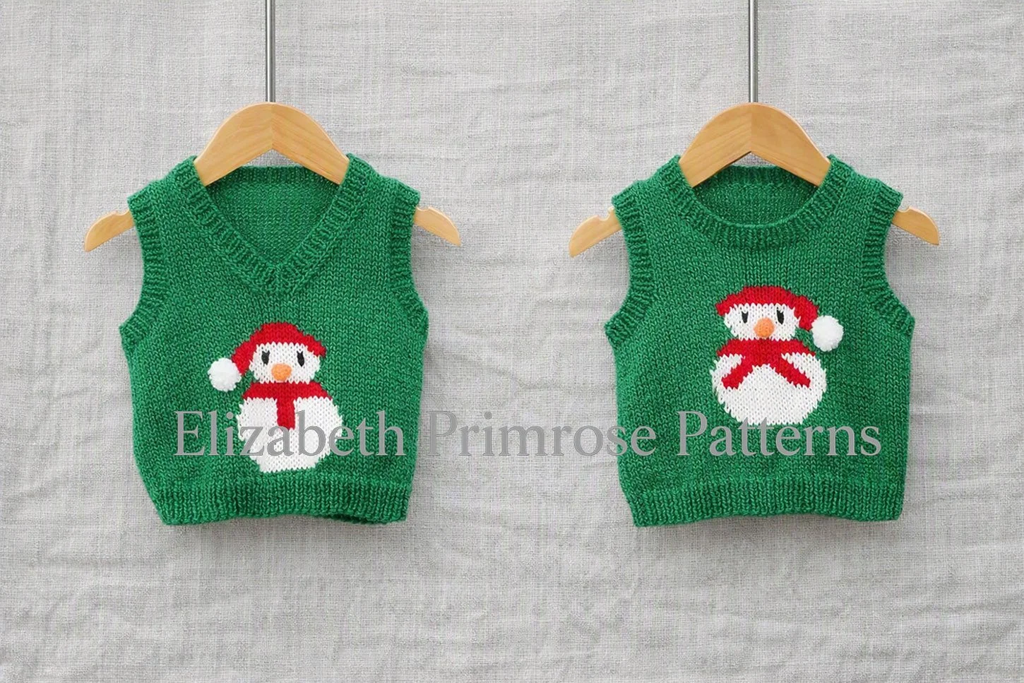 Green knitted snowman tank tops with round and V neck options hanging on wooden hangers against a light linen backdrop.