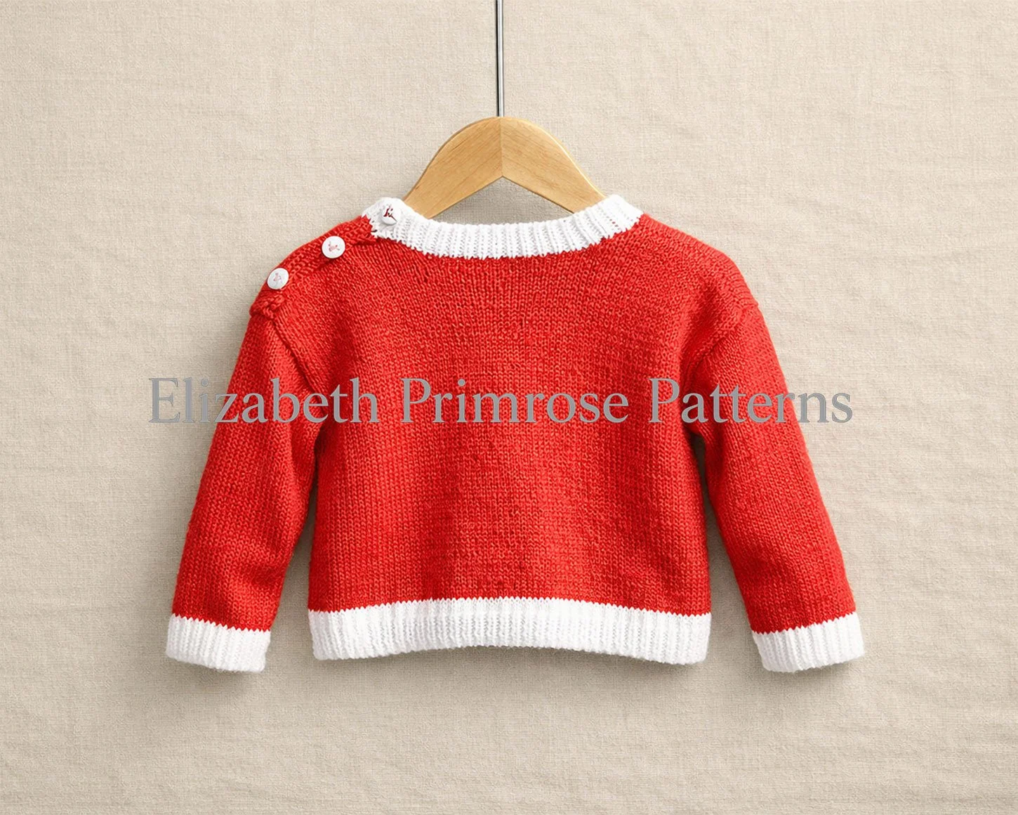 Back view of red children’s jumper with white ribbing and three shoulder buttons, hanging on a wooden hanger against a soft beige fabric background.