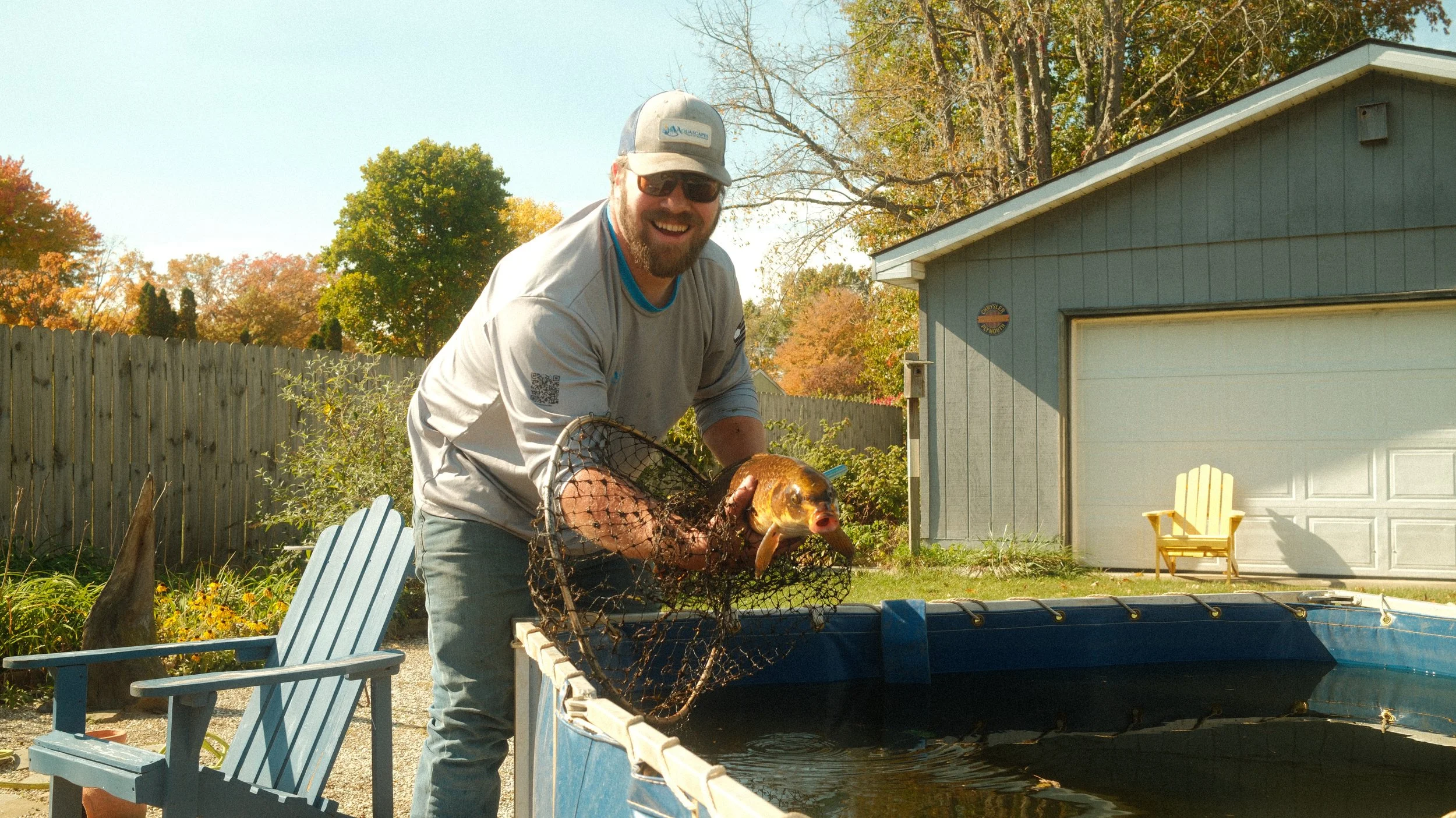 Aquascapes of Michiana holding a fish carefully during a professional pond cleaning