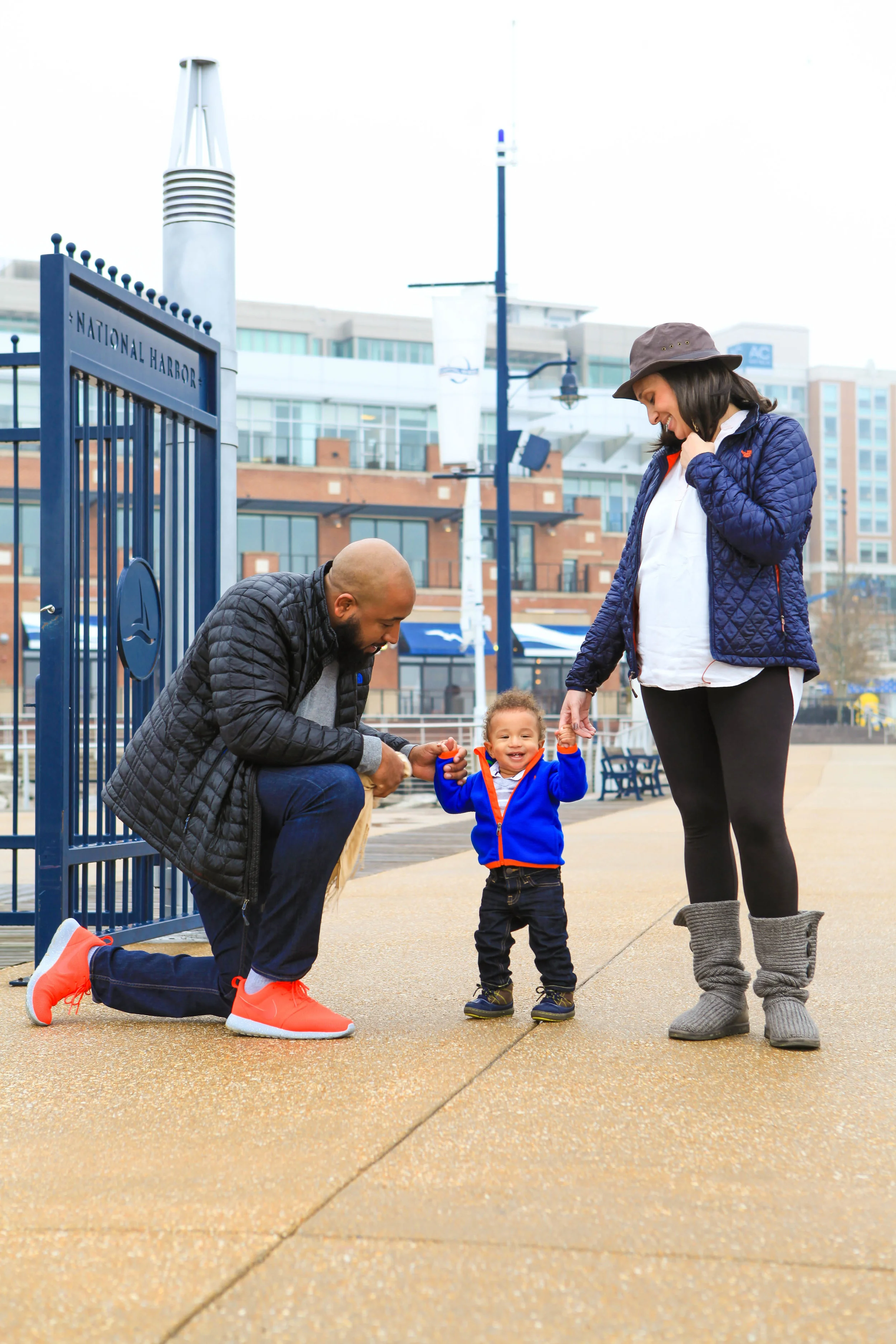 Pregnant couple on pier with toddler