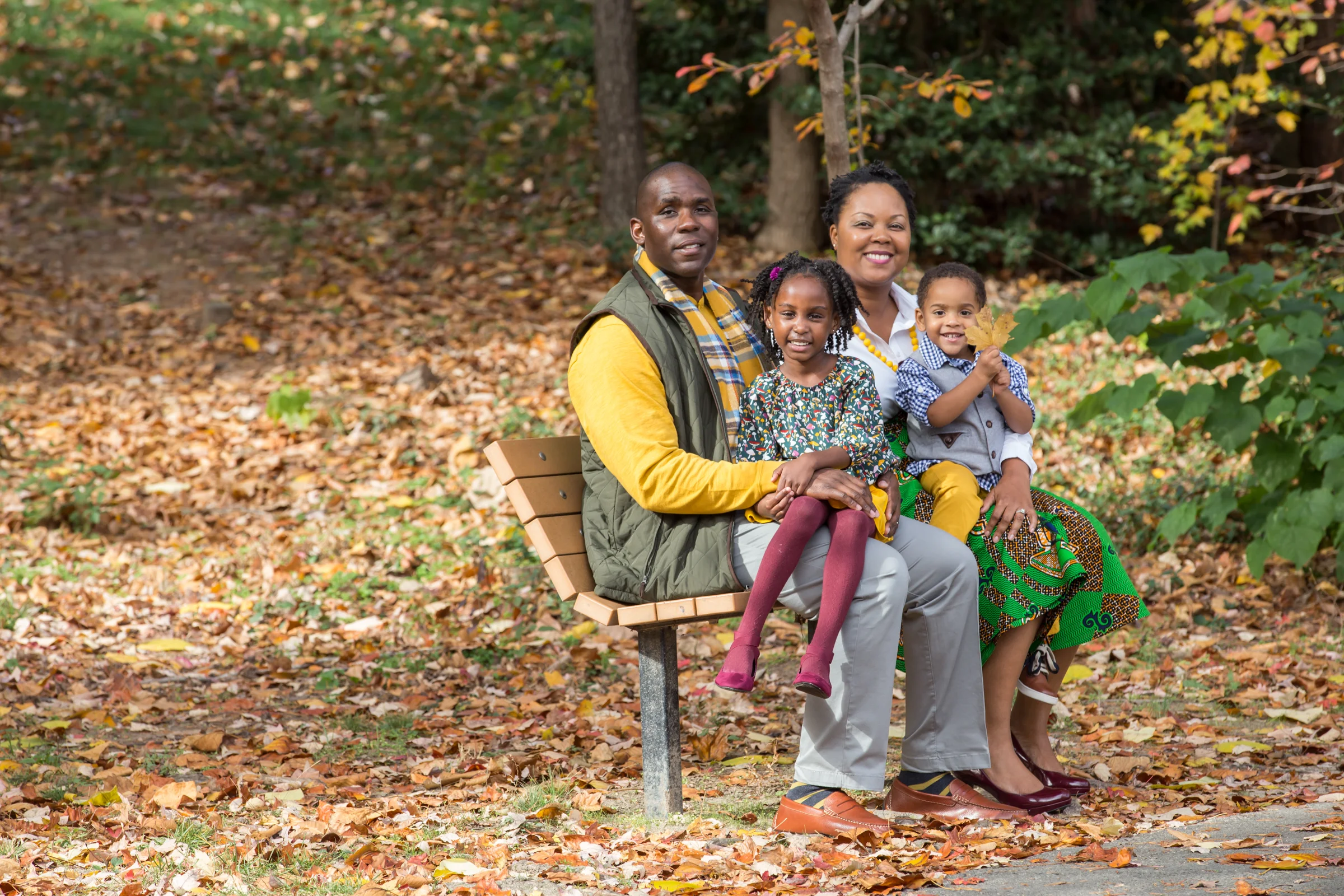 Family sitting on bench smiling at the camera