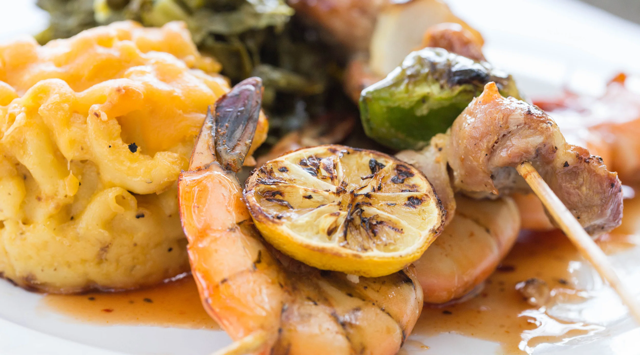 Plate of shrimp and kabob with macaroni and cheese