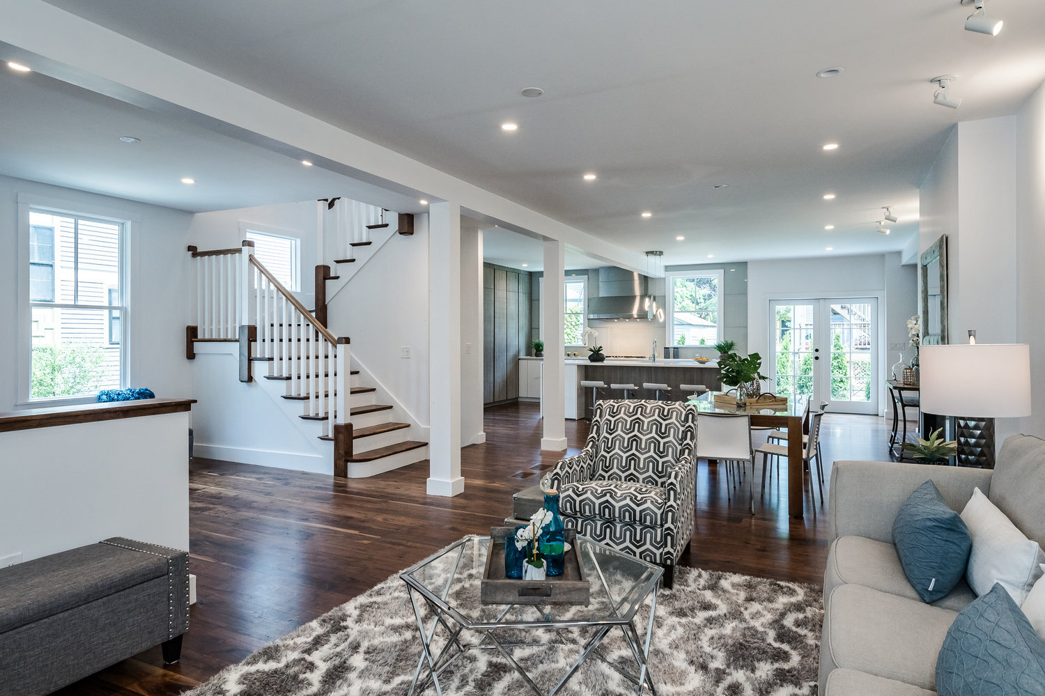 Modern brookline home renovation mixed with dutch colonial style. white staircase with dark wood accents and transitional style furniture