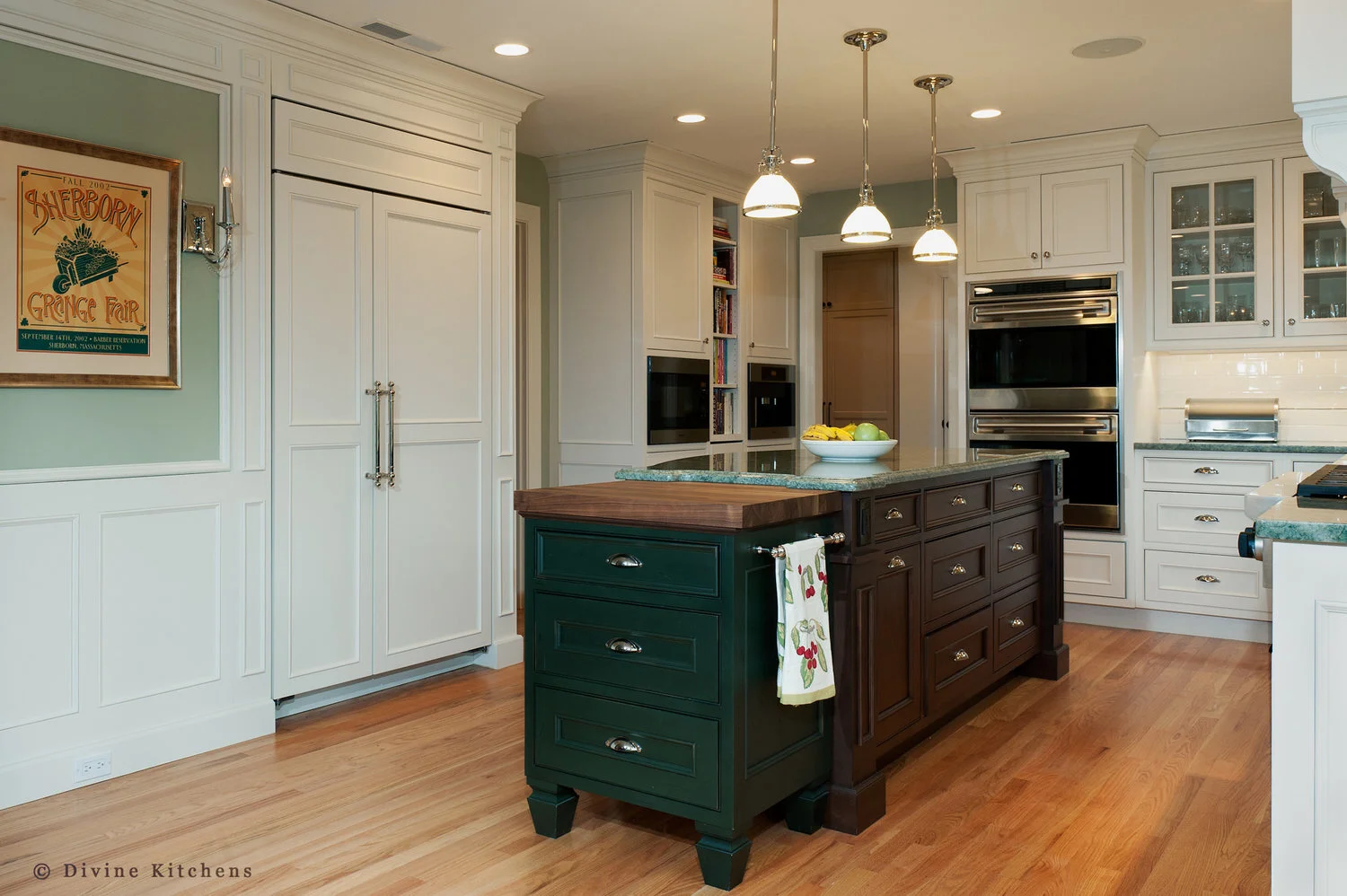 Traditional Kitchen with white shaker cabinetry and double decker appliances. Marble countertops float above a kitchen island and medium hardwood floors. A laundry room is adjacent to the kitchen.