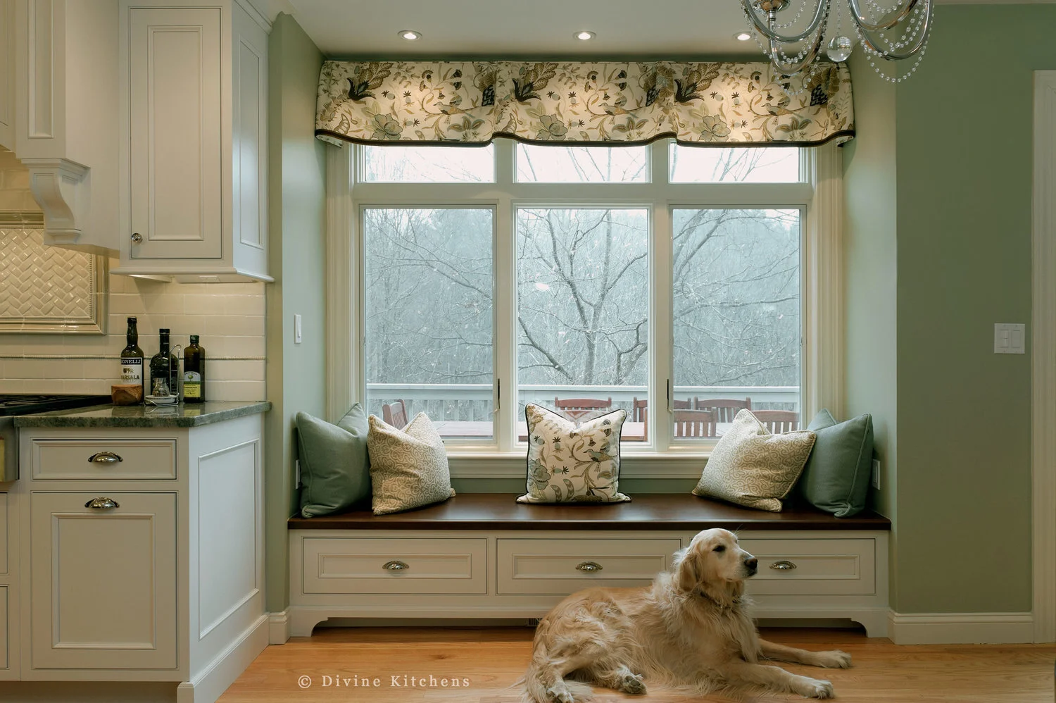 Traditional Kitchen with white shaker cabinetry and double decker appliances. Marble countertops float above a kitchen island and medium hardwood floors. A laundry room is adjacent to the kitchen.