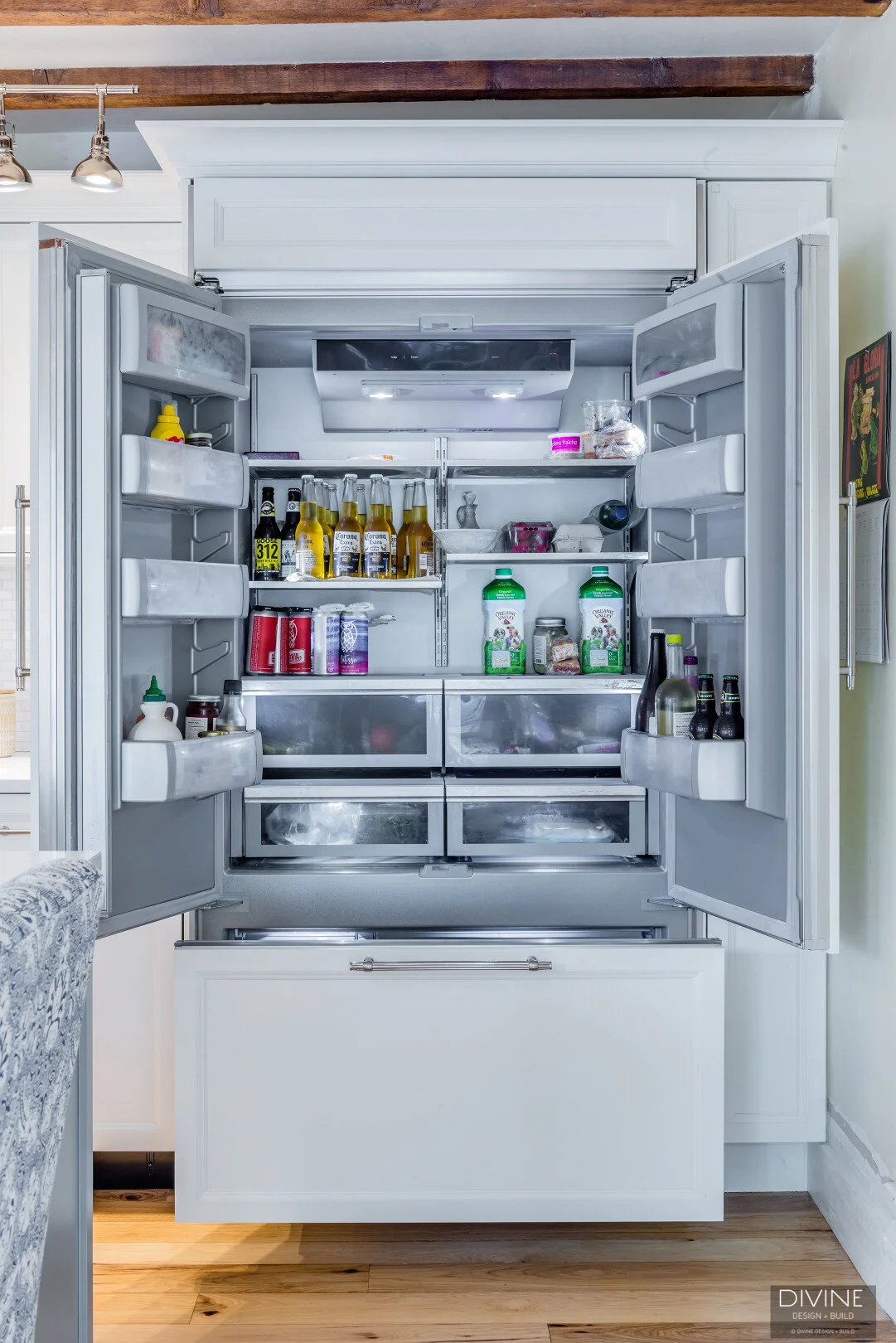 white, shaker style cabinets with brushed nickel accessories, white mosaic subway tile backsplash, cambria countertops with light marbling in grey tone and a paneled refrigerator
