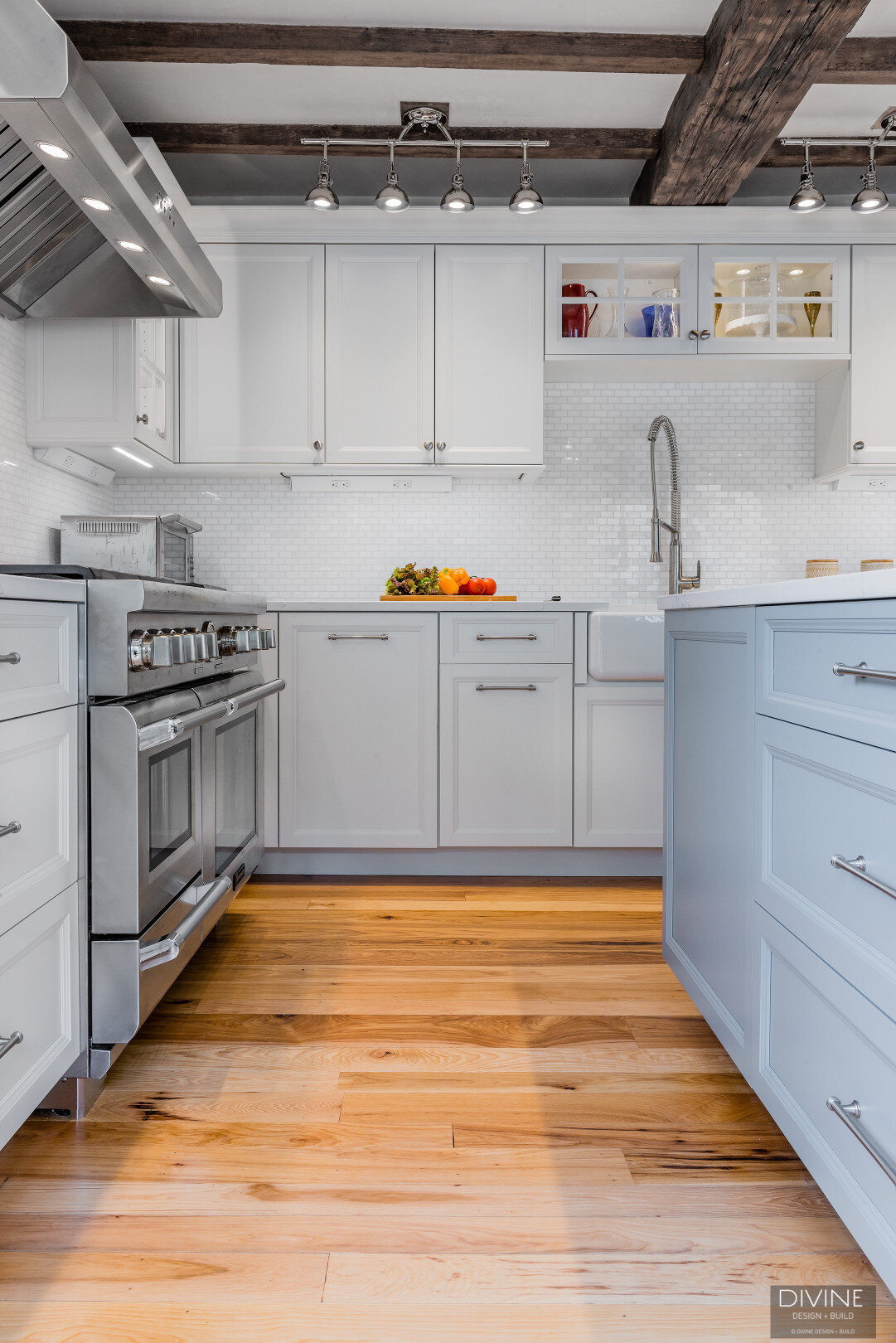 white, shaker style cabinets with brushed nickel accessories, white mosaic subway tile backsplash, cambria countertops with light marbling in grey tone and a paneled refrigerator
