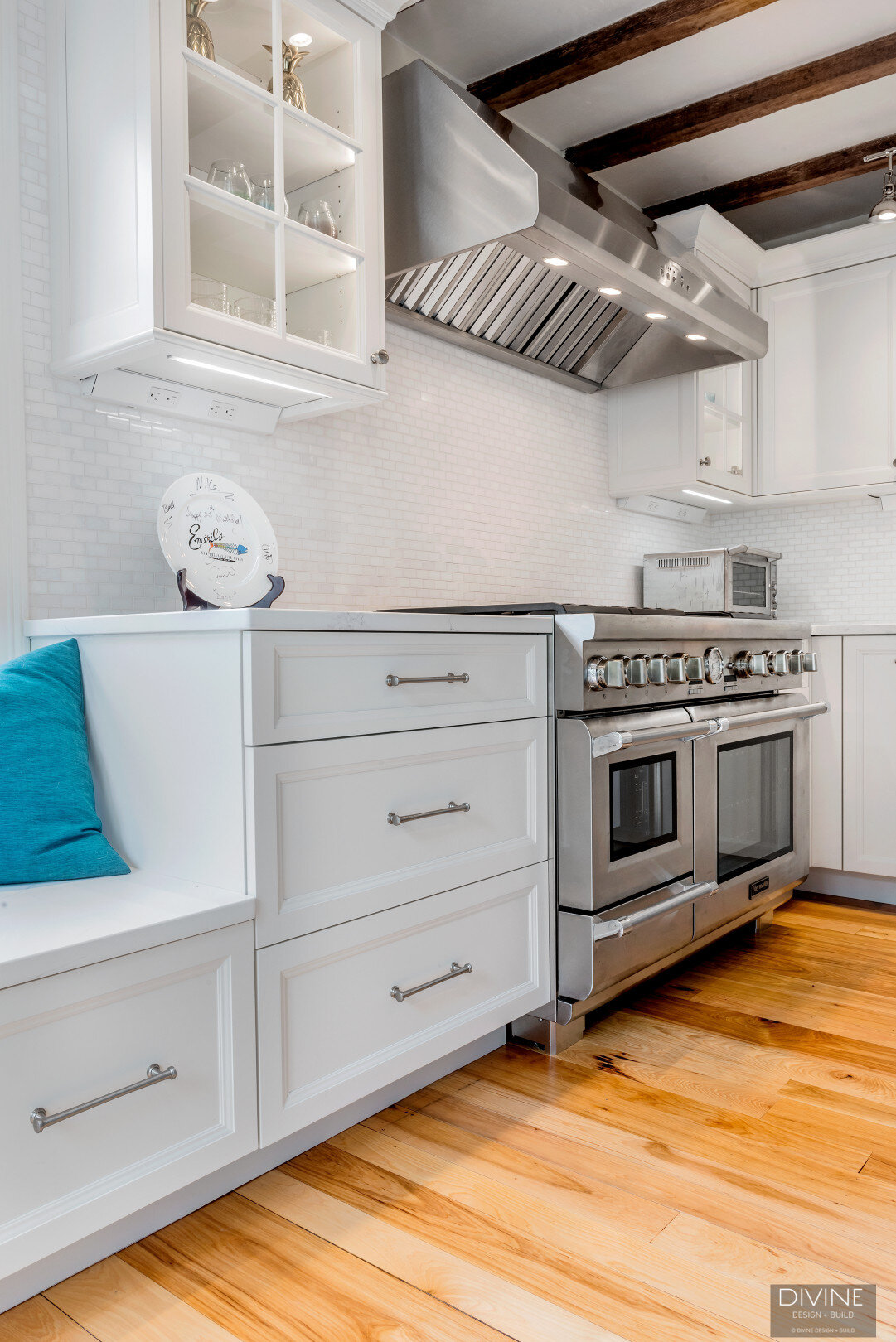 white, shaker style cabinets with brushed nickel accessories, white mosaic subway tile backsplash, cambria countertops with light marbling in grey tone and thermador appliances