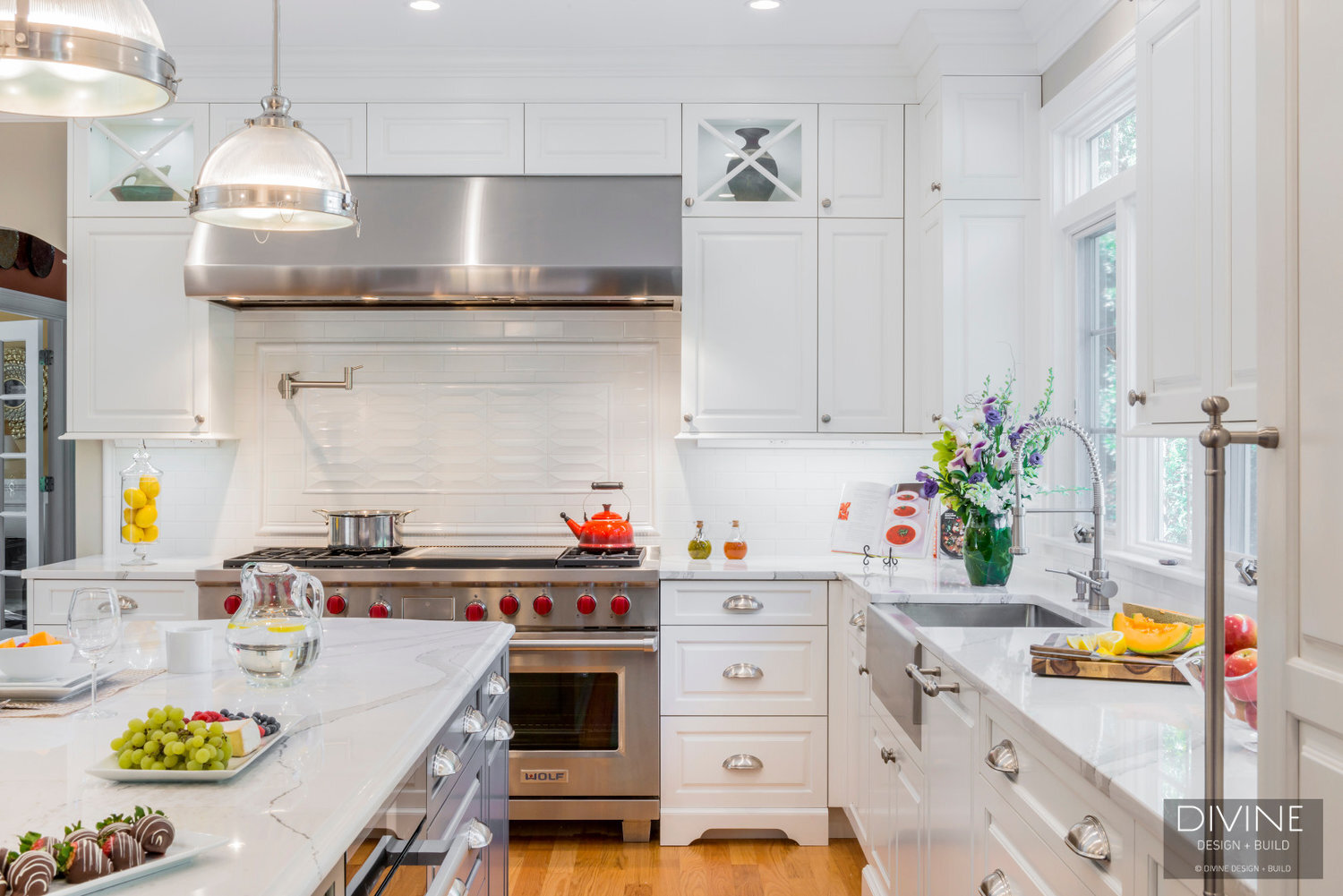  traditional shaker style kitchen. wolf appliances and chrome pendant lights. Calacatta countertops and medium hardwood floors. pull out pantry storage.