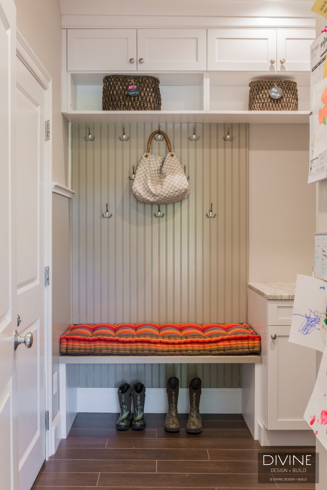  traditional mudroom with white shaker cabinets, and bench seat with shoe storage below it. 