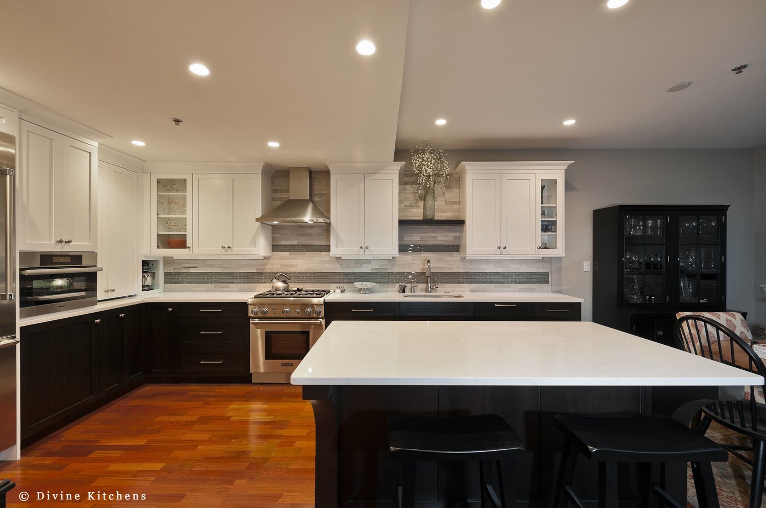 Transitional style kitchen with mosaic tile backsplash. Navy blue and white shaker style cabinets. stainless steel appliances and task power strips. 