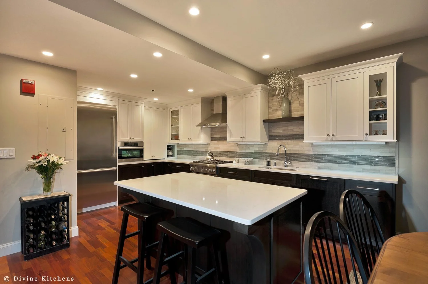 Transitional style kitchen with mosaic tile backsplash. Navy blue and white shaker style cabinets. stainless steel appliances and task power strips. 