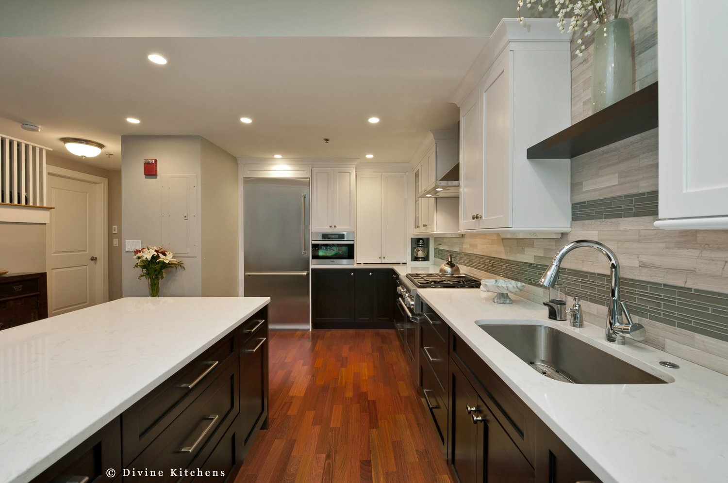 Transitional style kitchen with mosaic tile backsplash. Navy blue and white shaker style cabinets. stainless steel appliances and task power strips. 