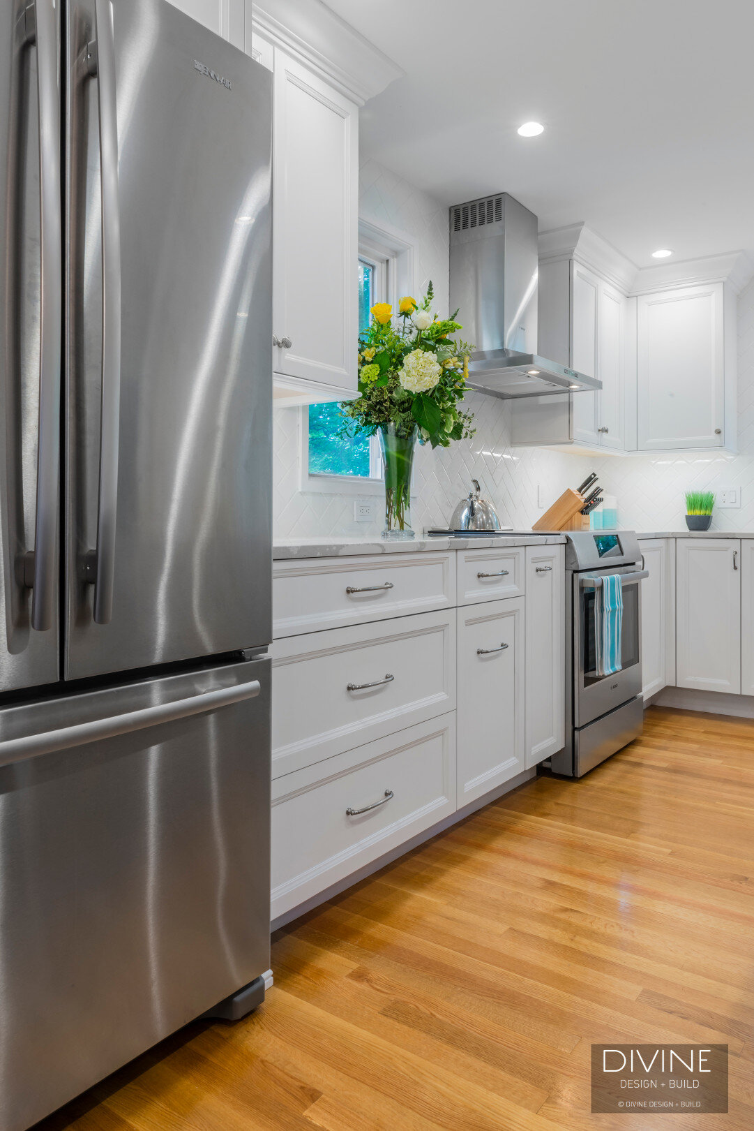 White and grey transitional style kitchen with shaker cabinets and stainless steel appliances. beveled subway tile backsplash in white. 
