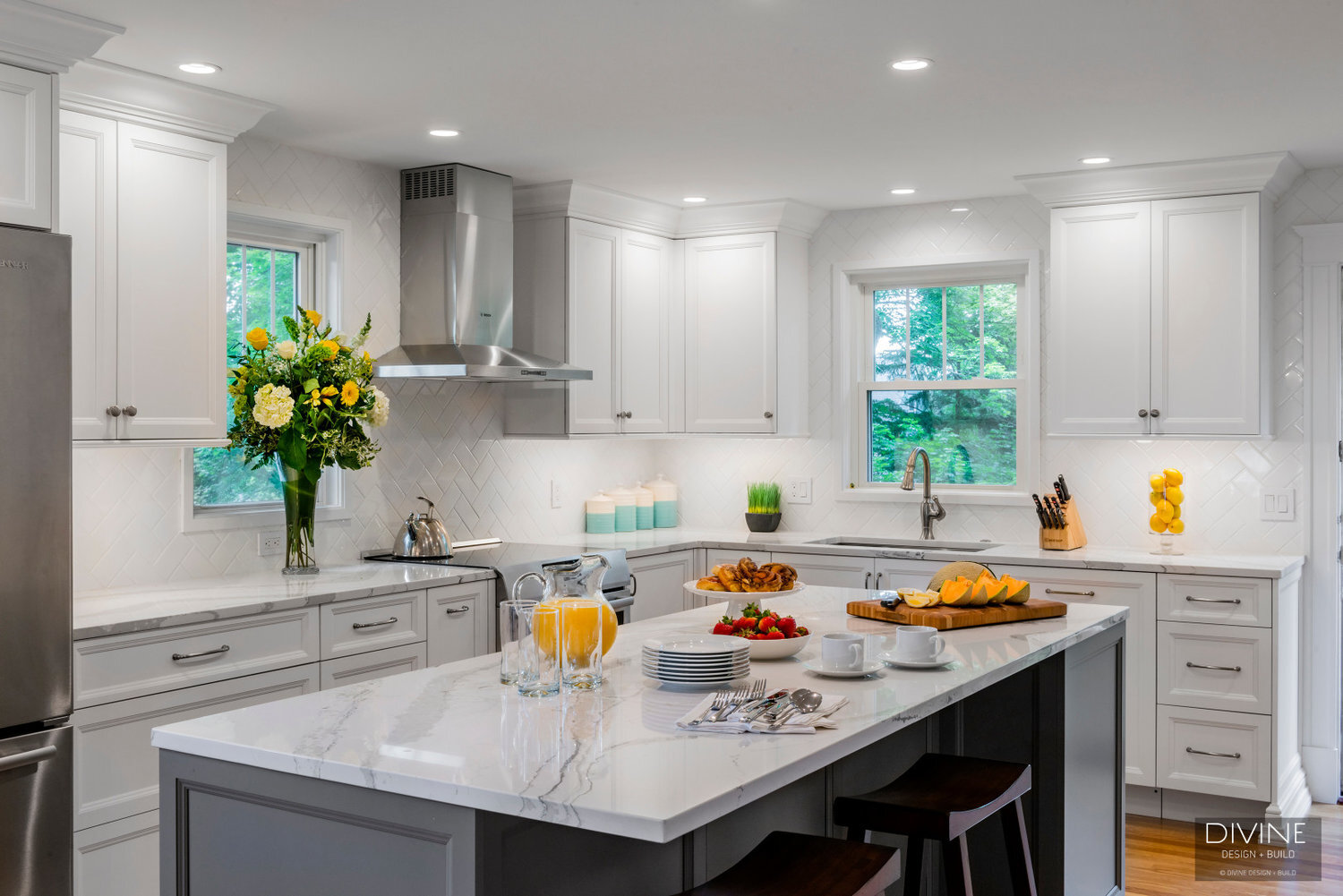 White and grey transitional style kitchen with shaker cabinets and stainless steel appliances. beveled subway tile backsplash in white. 