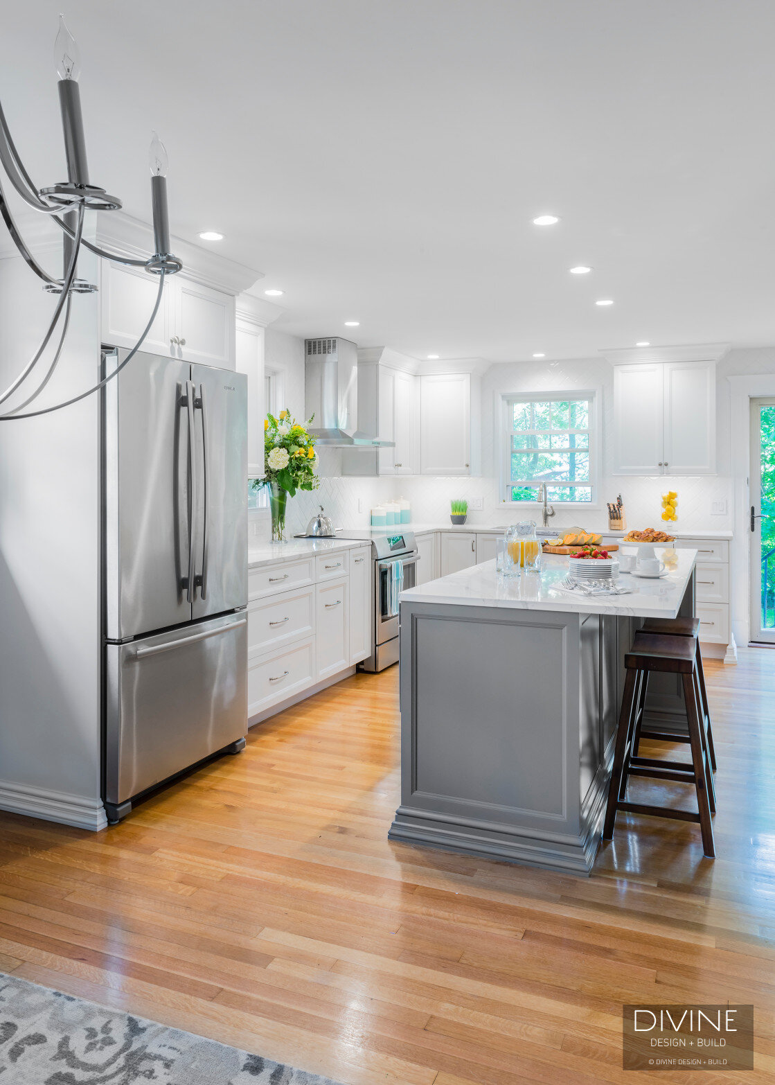  White and grey transitional style kitchen with shaker cabinets and stainless steel appliances. beveled subway tile backsplash in white. 