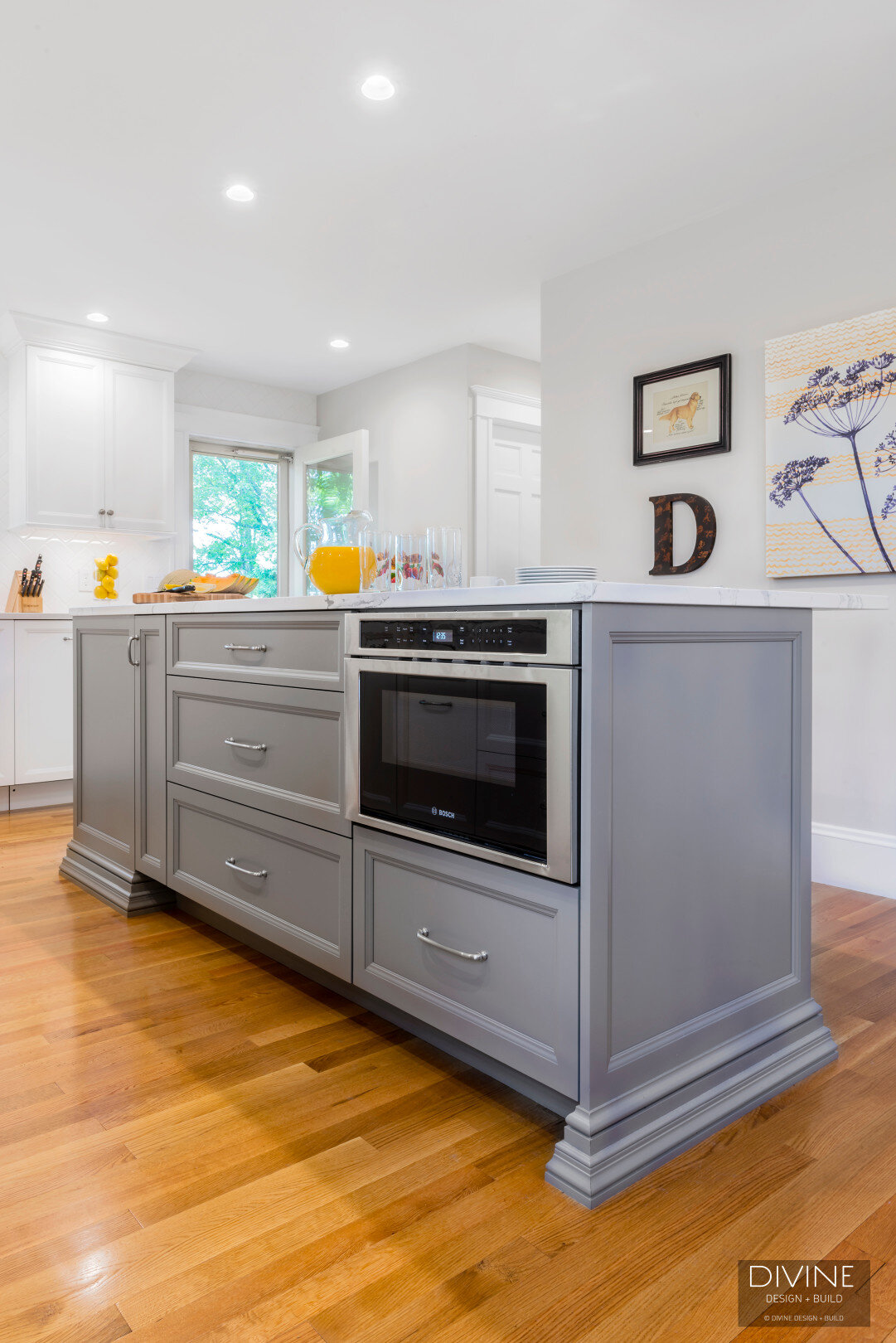  White and grey transitional style kitchen with shaker cabinets and stainless steel appliances. beveled subway tile backsplash in white. 