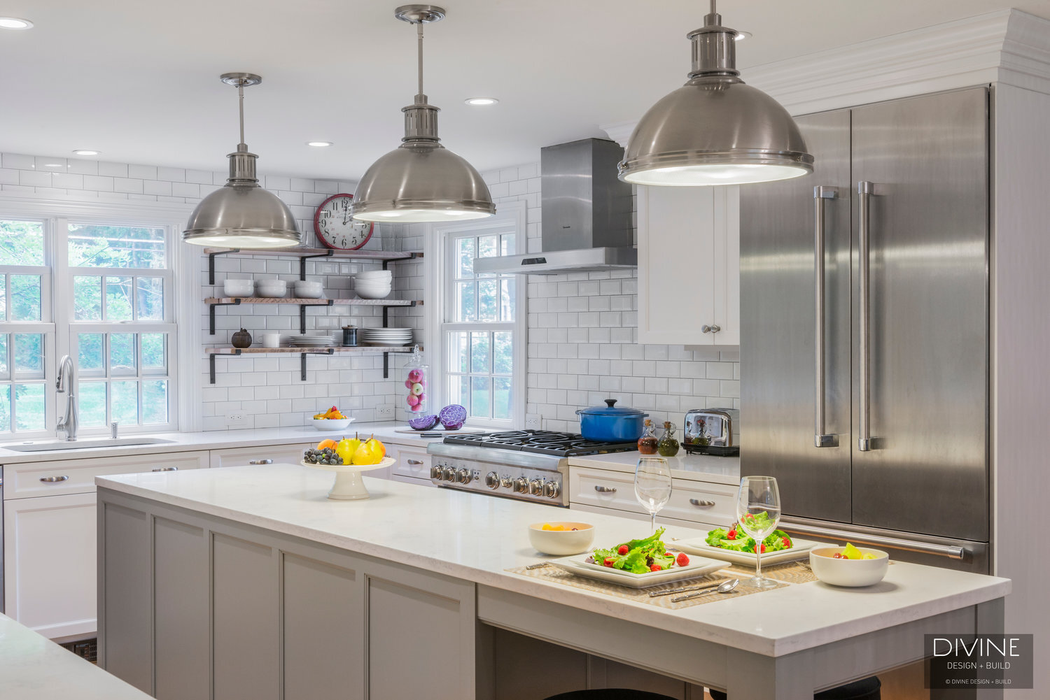  Grey and white transitional style kitchen with shaker cabinets and integrated dog feeding station. Chalkboard. Subway tile backsplash and industrial style lights and shelving