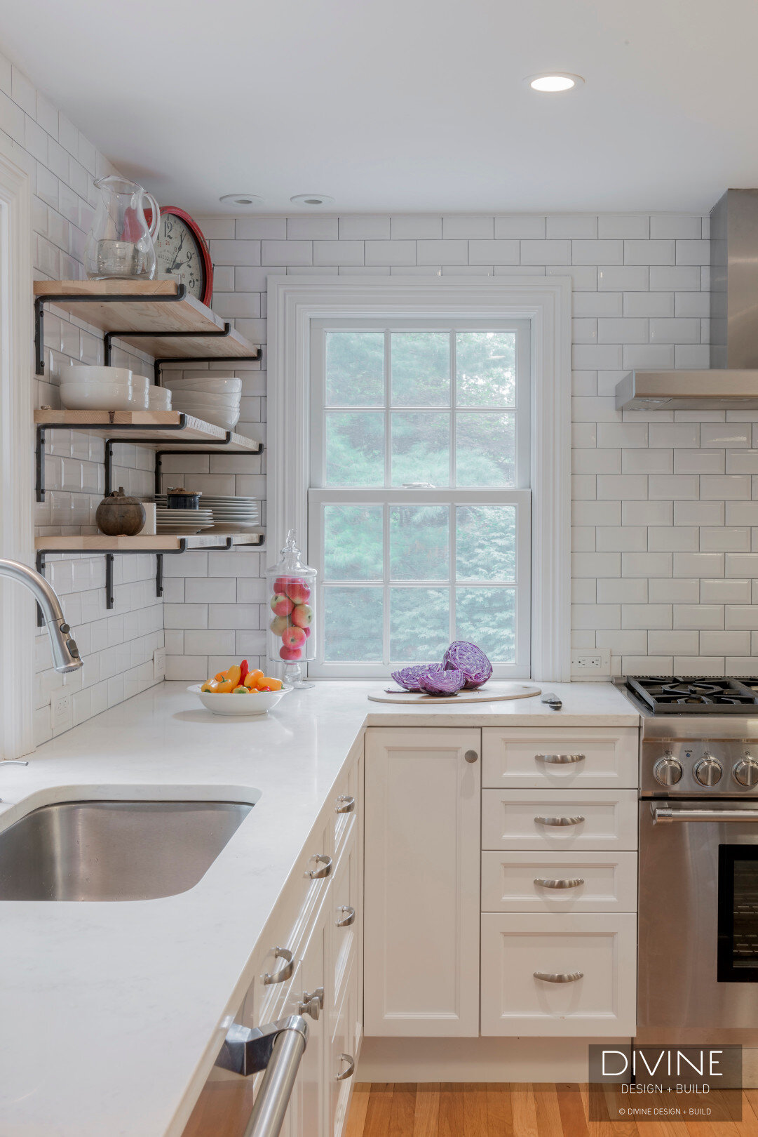  Grey and white transitional style kitchen with shaker cabinets and integrated dog feeding station. Chalkboard. Subway tile backsplash and industrial style lights and shelving