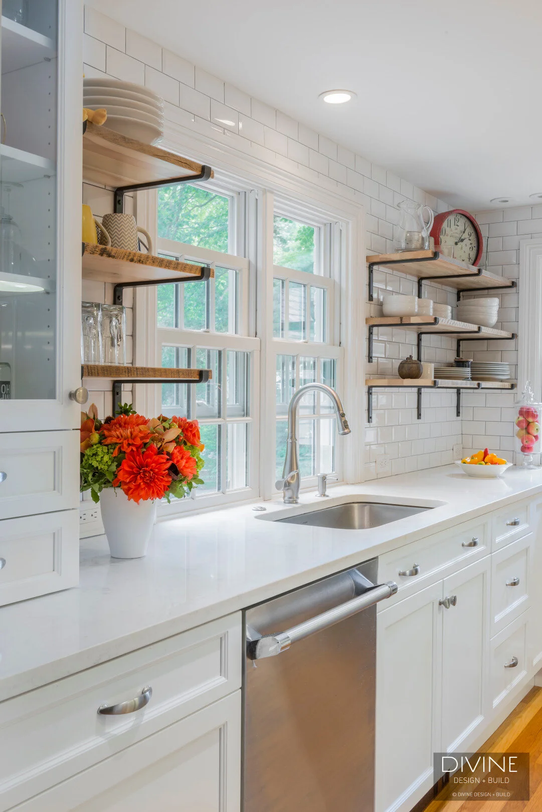  Grey and white transitional style kitchen with shaker cabinets and integrated dog feeding station. Chalkboard. Subway tile backsplash and industrial style lights and shelving