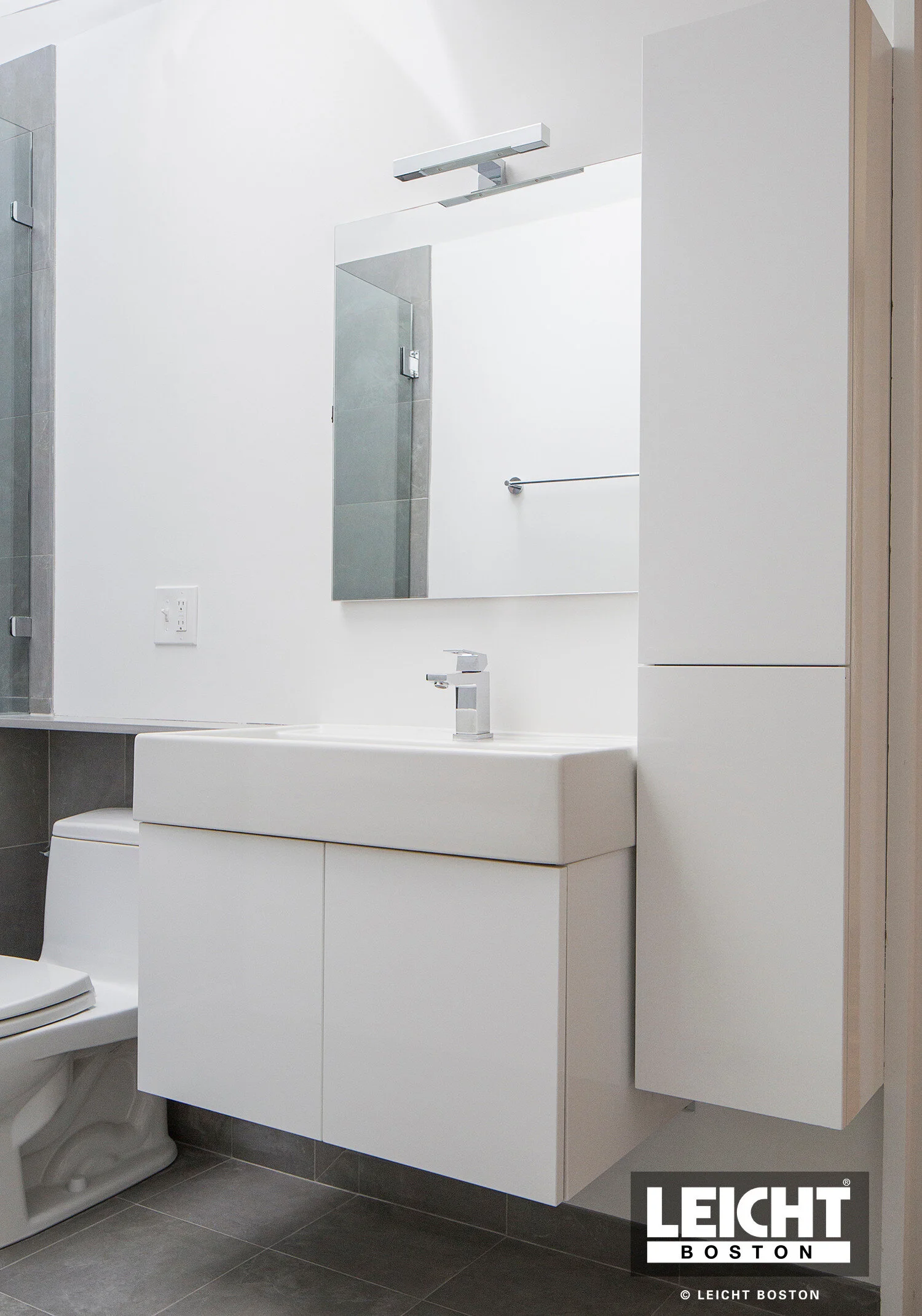  Leicht bathroom vanity and suspended floating cabinet in matt white lacquer. grey stone tiled floors.