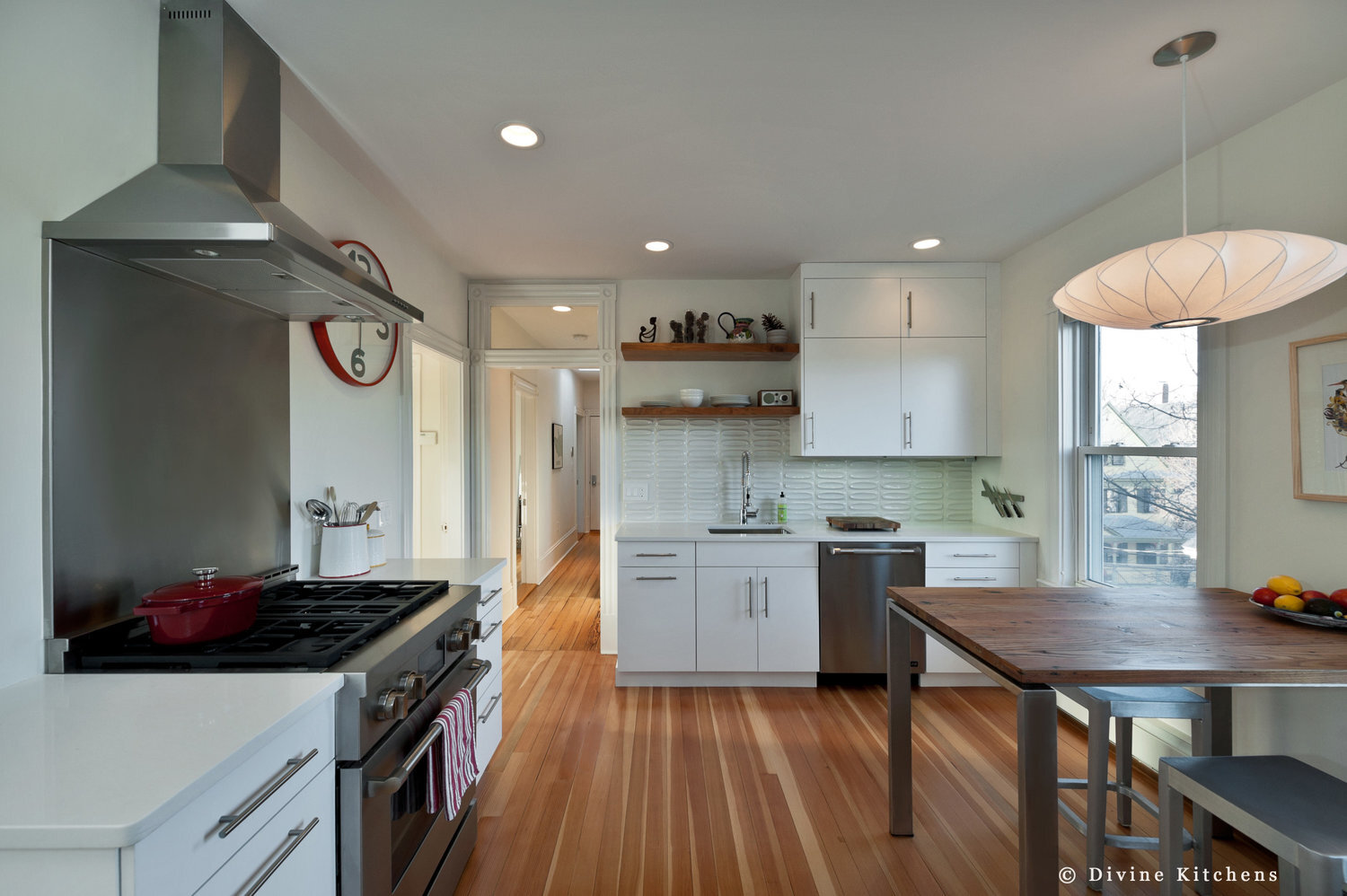 White transitional style kitchen with seafoam glass tile backsplash. Brushed nickel accessories. Stainless steel appliances. Cambria quartz countertops. 