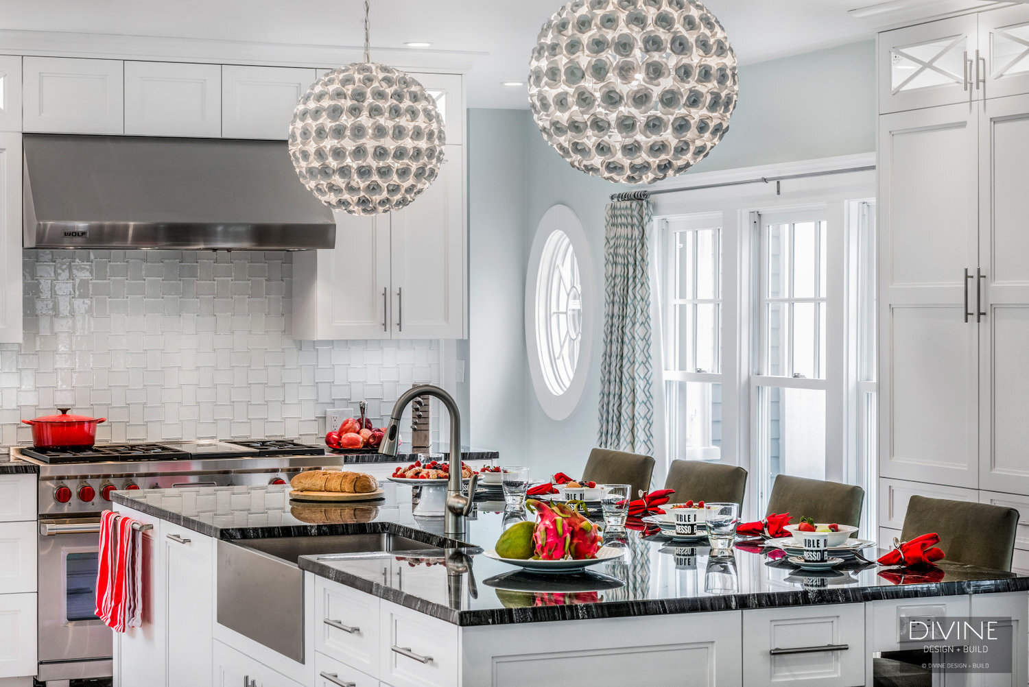  Floral sphere pendant lights with glass tiled back splash. Wolf appliances, stainless steel farmhouse sink. Granite countertops, and white shaker style cabinets.